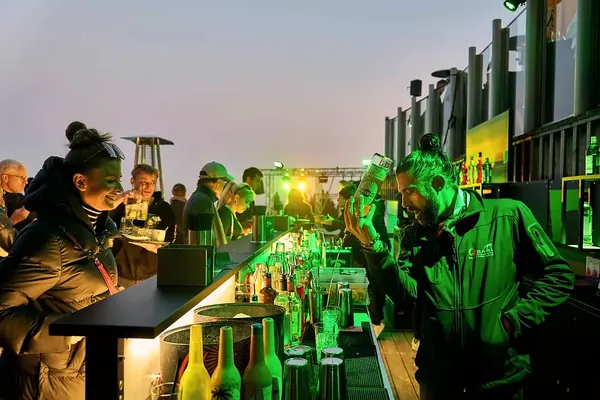 Barkeeper mixt Cocktails für Gäste auf einem Firmenevent am Abend