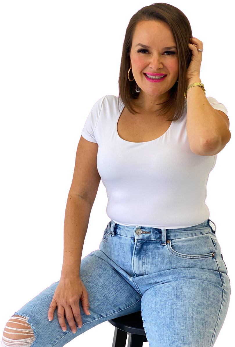 Photo of Andrea smiling and her one hand holding her hair while sitting on a black stool