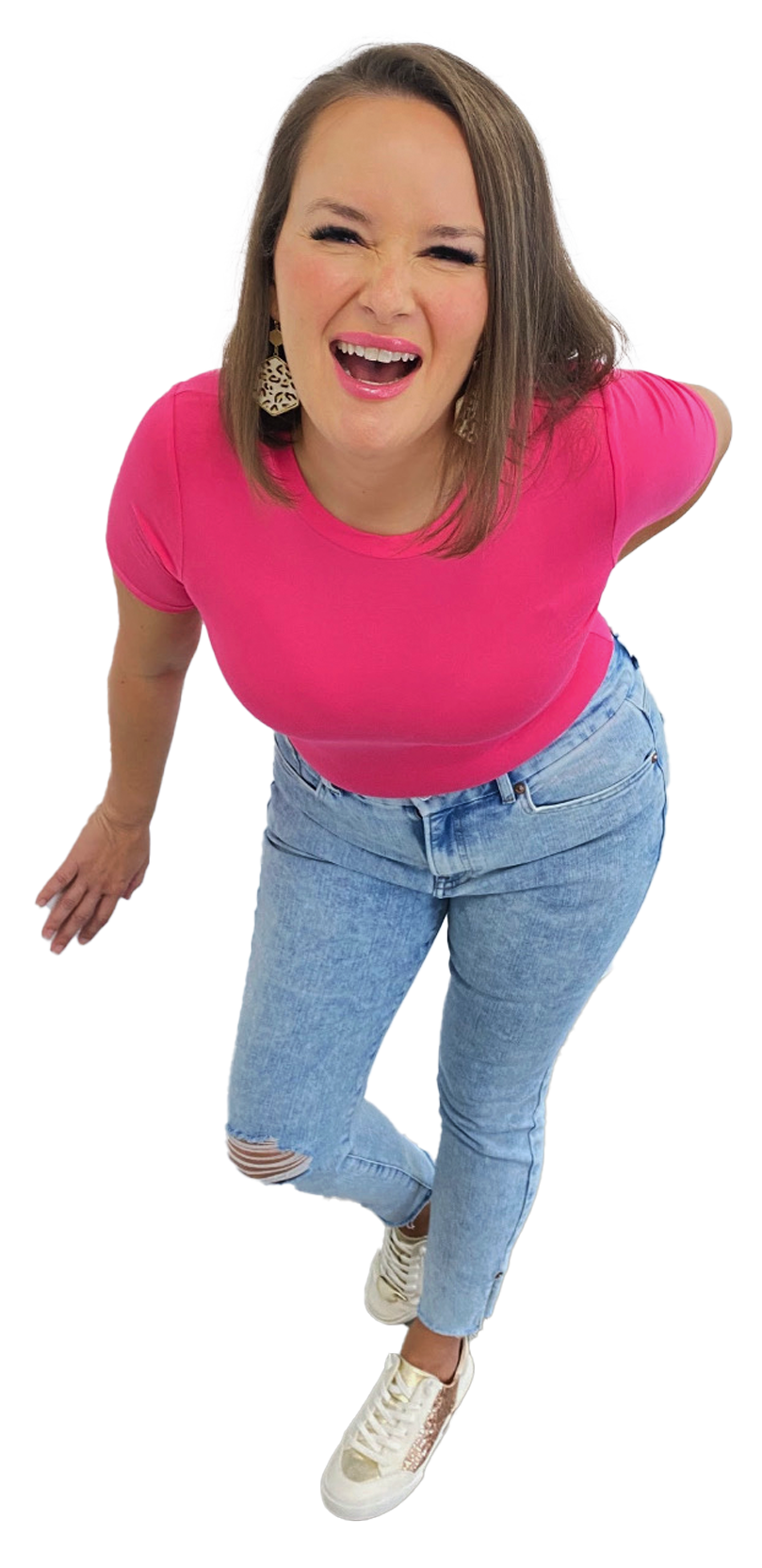 Photo of Andrea Smiling with her one hand touching the wall and her other hand on her hips
