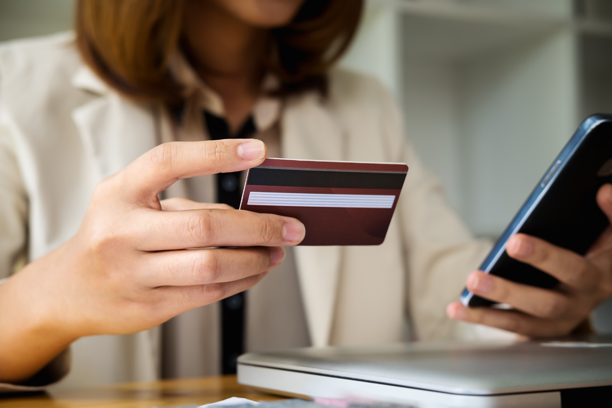 Women buying something on her phone with a credit card. 