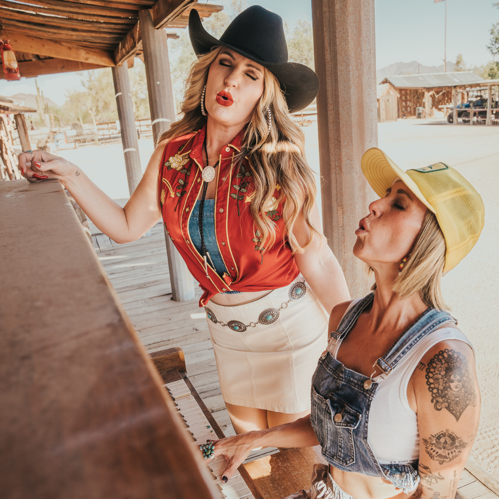 Close-up of Gretchen Seeck and Missy Stern laughing together in a rustic outdoor setting.