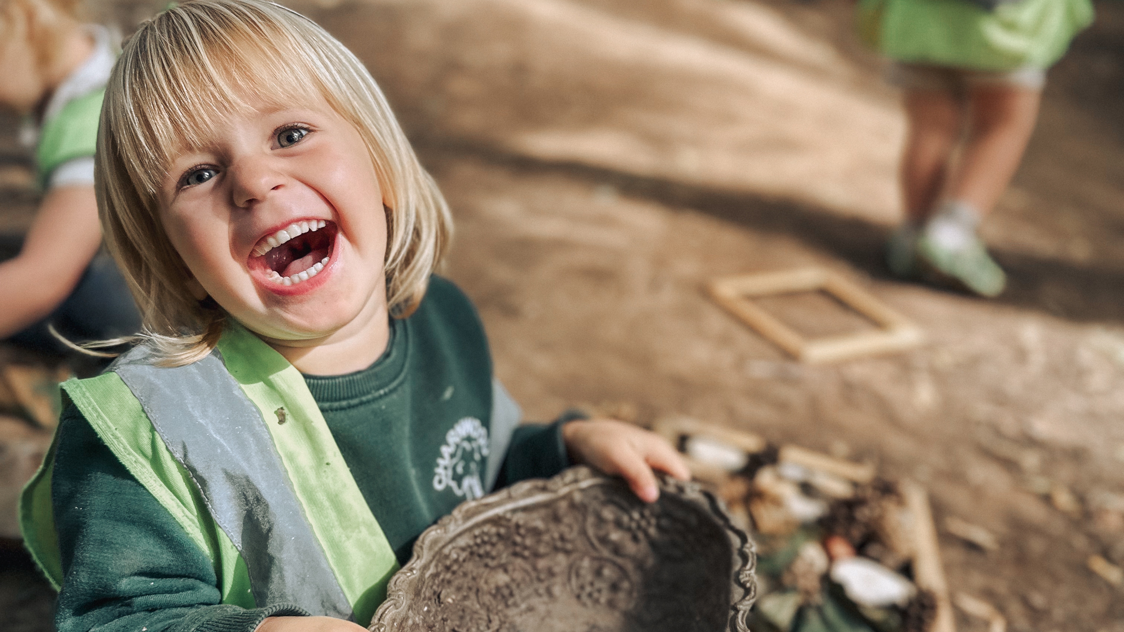 a little boy is playing with a toy in the grass