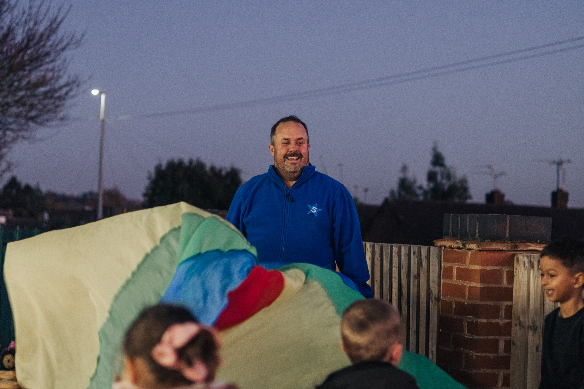 Boy in doctor's coat listens to grandfather's heart.