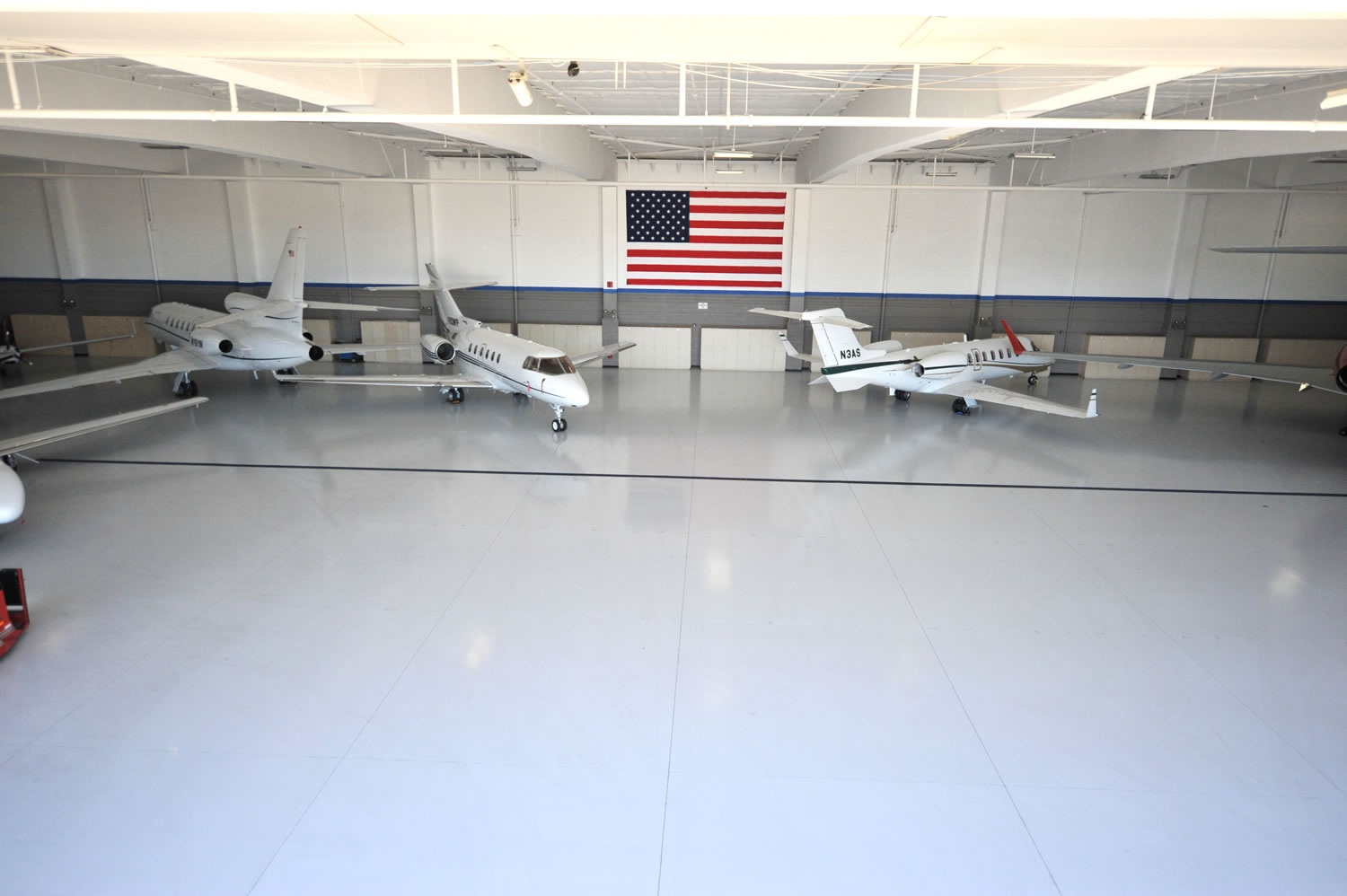 A white car in a garage with a finished floor