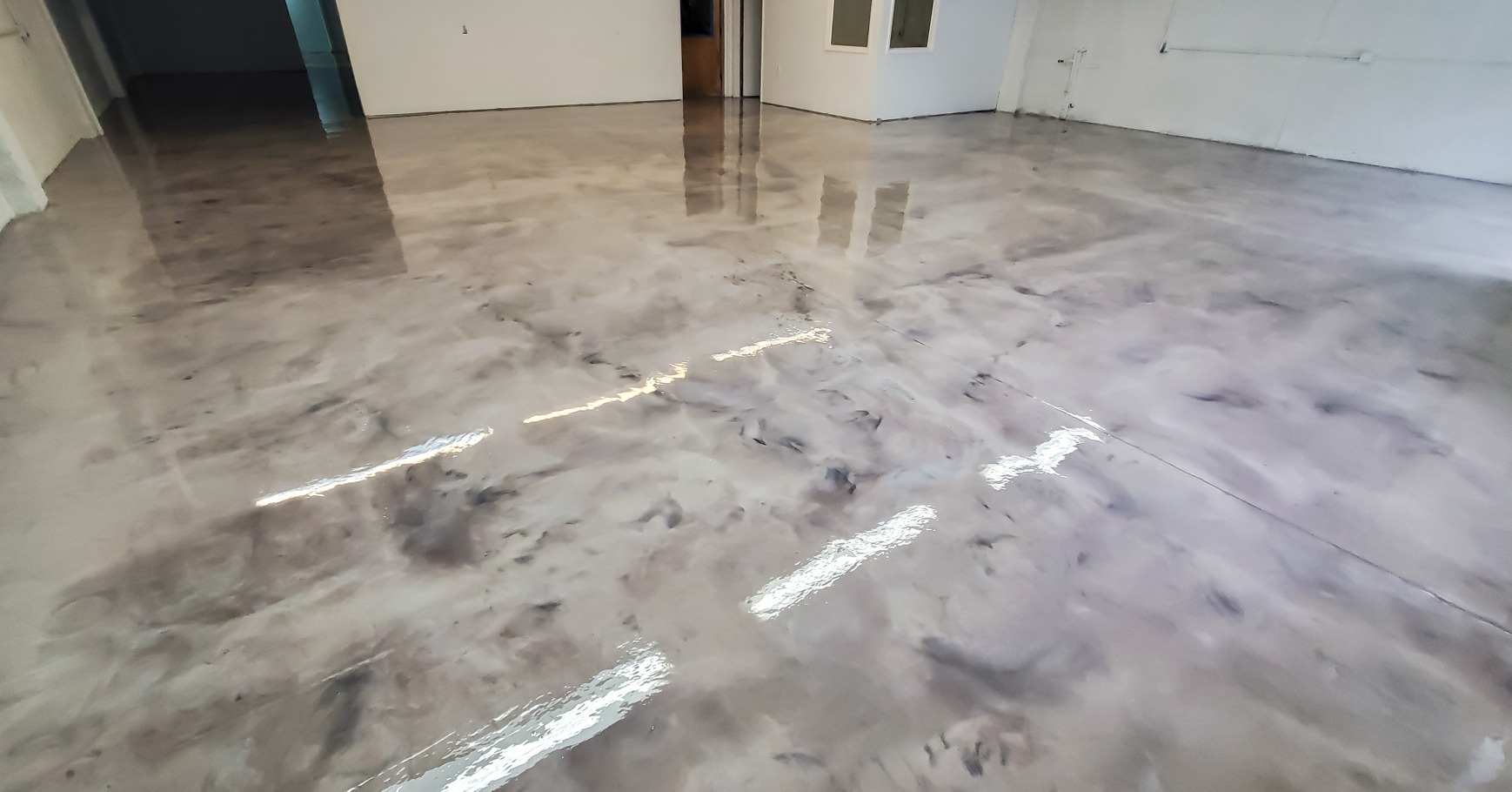 A white car in a garage with a finished floor