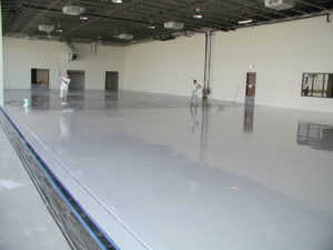 A white car in a garage with a finished floor