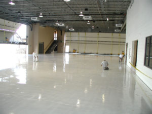 A white car in a garage with a finished floor