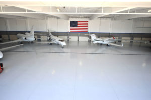 A white car in a garage with a finished floor