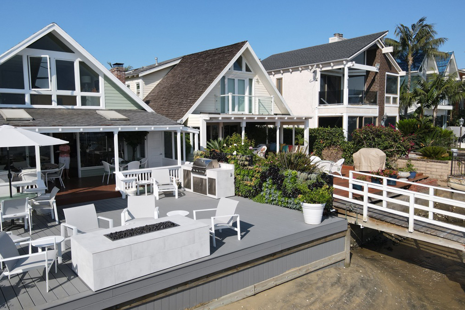 Waterfront residential patio with living wall and outdoor fire table