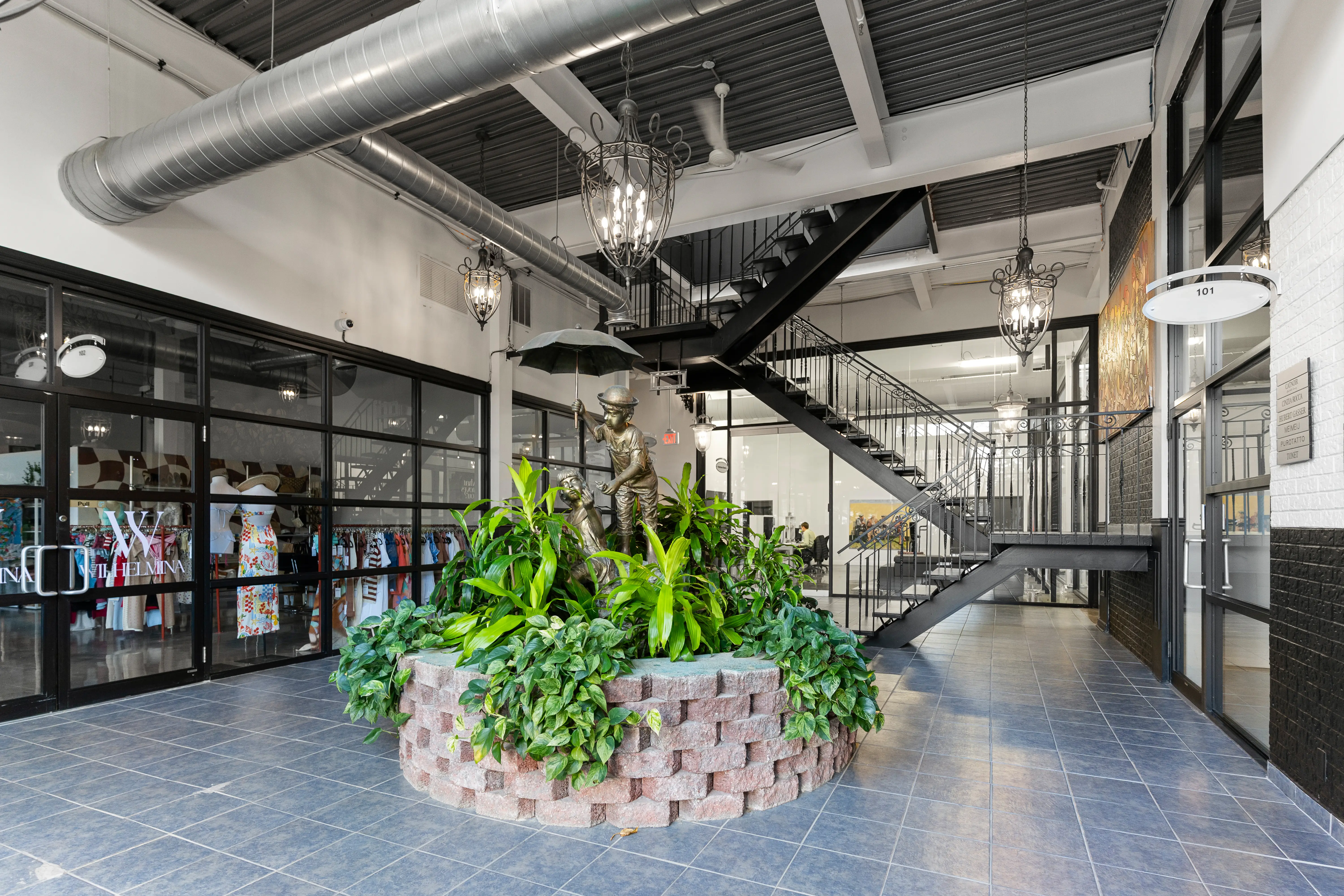 Modern interior lobby of FayLaura Investments featuring a skylight, open staircase, and indoor greenery — Toronto commercial real estate