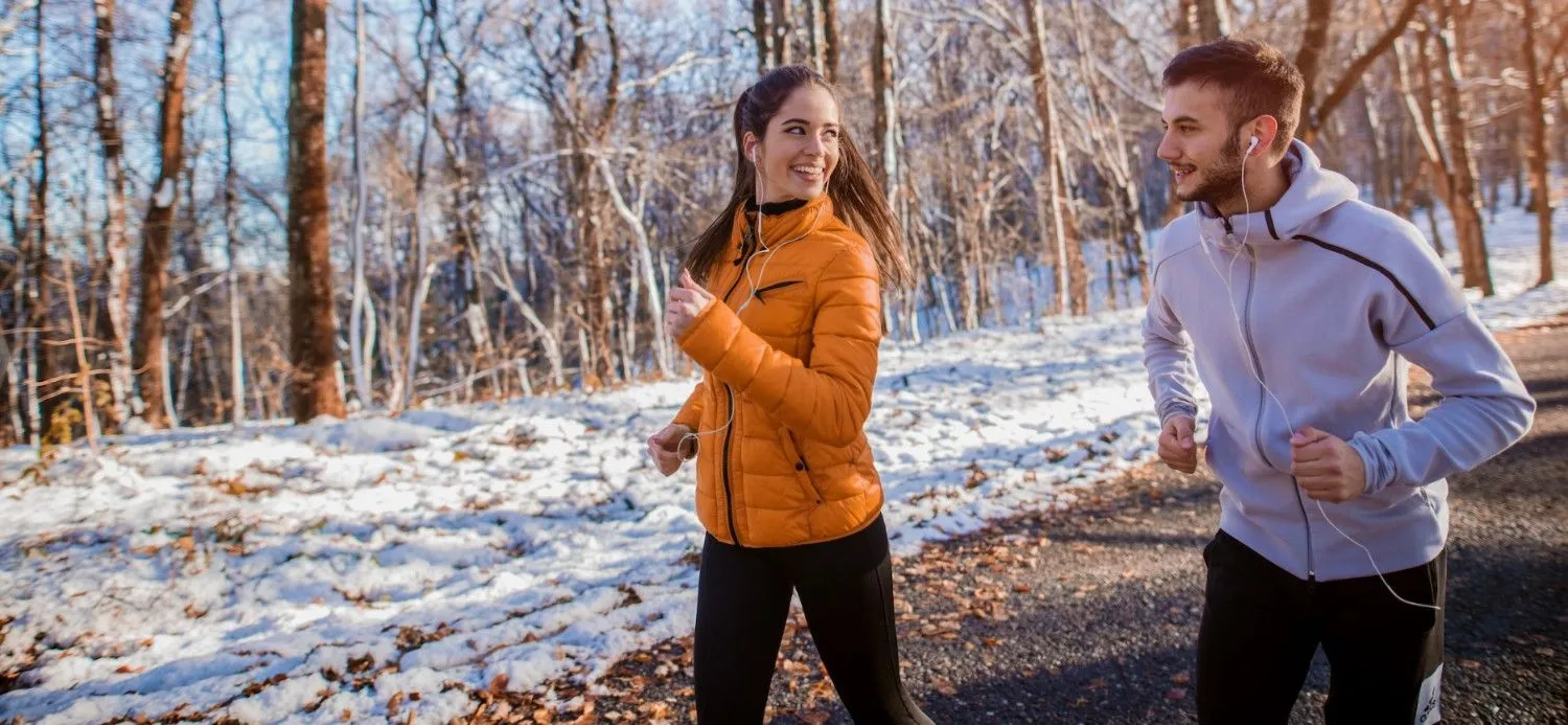 Active couple jogging in winter, representing joint mobility