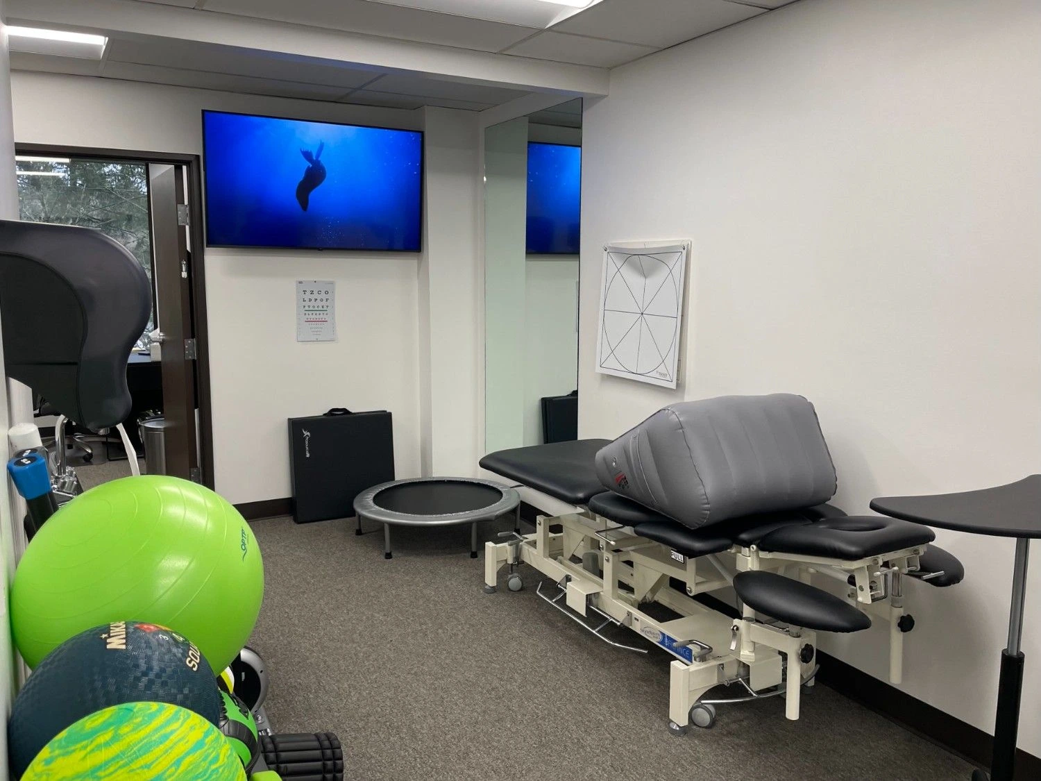 Therapy room with treatment table and exercise equipment