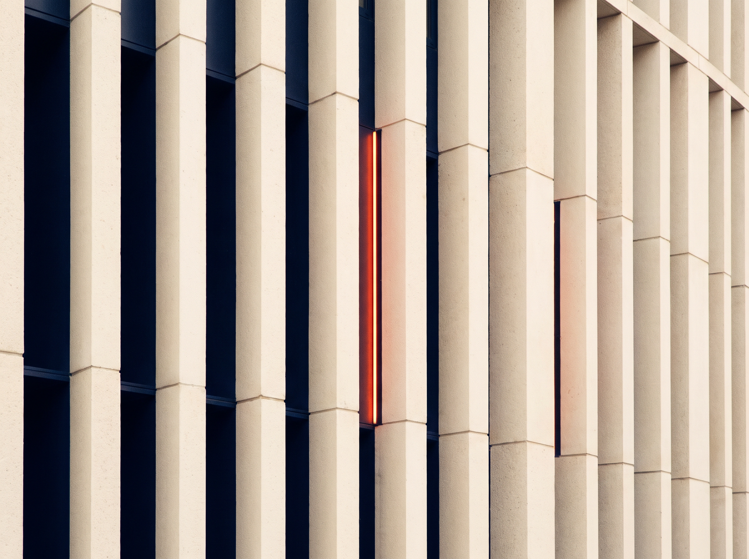 Fachada cívica de columnas con una franja de luz naranja