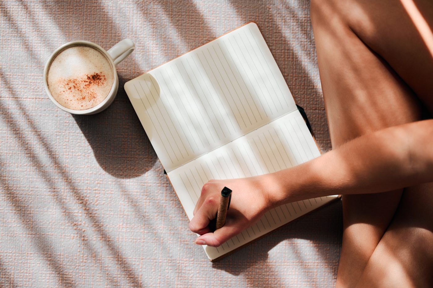 An open journal and a cup of coffee in morning light
