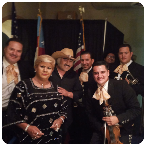 Mariachi Juvenil Grullense with celebrity performers during a special award ceremony with American and Puerto Rican flags.
