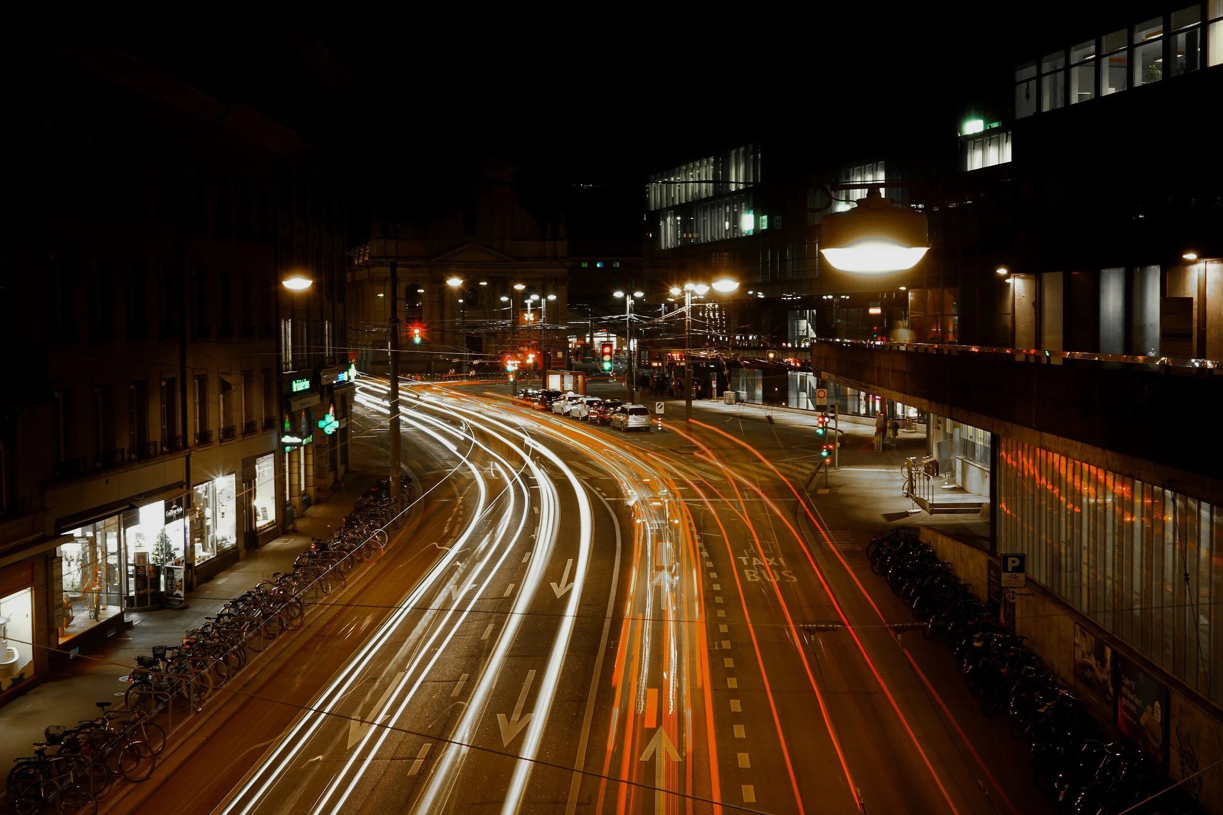 Nighttime city street with light trail effects from moving vehicles and lit buildings