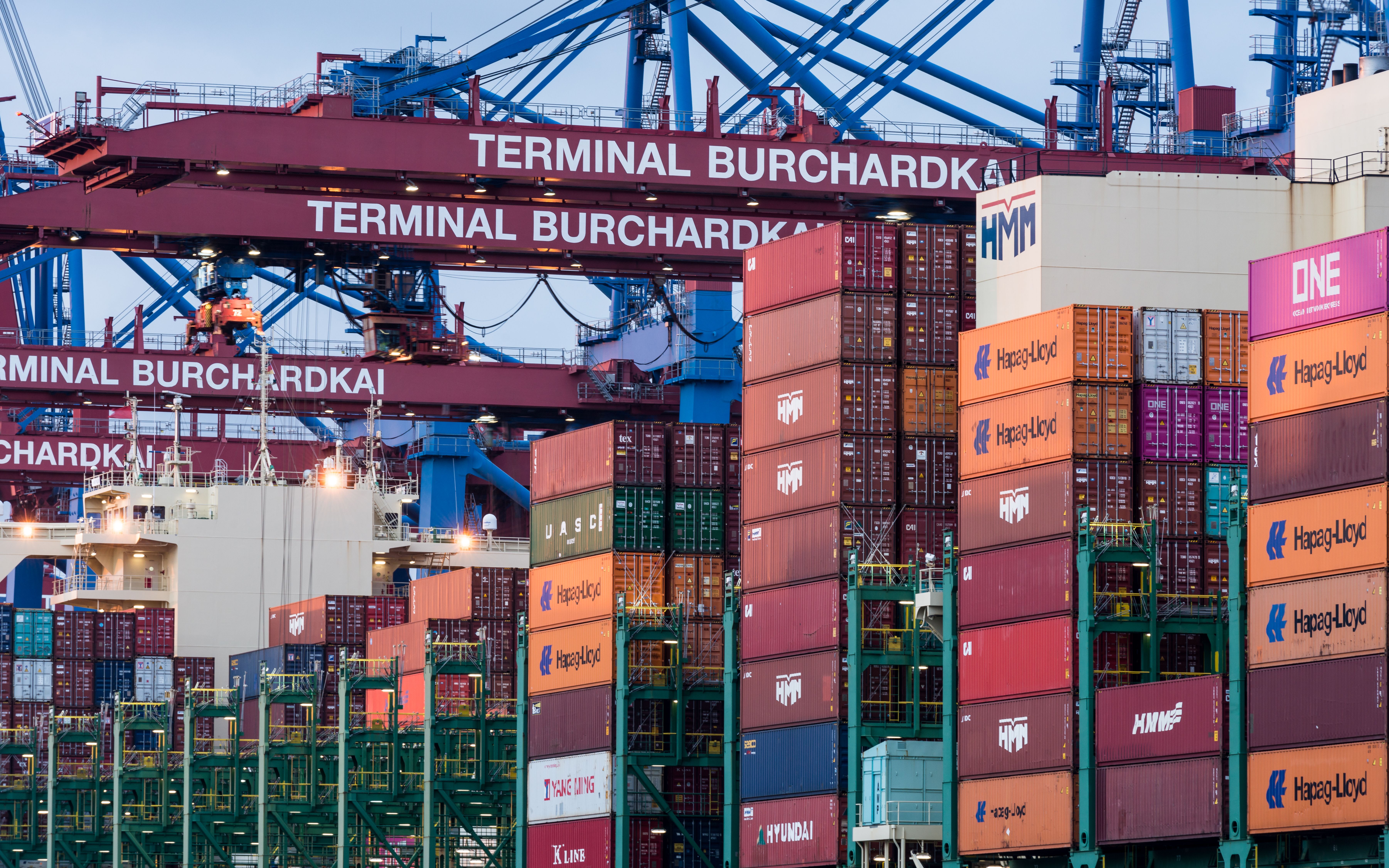 Container terminal with stacked shipping containers and quayside cranes