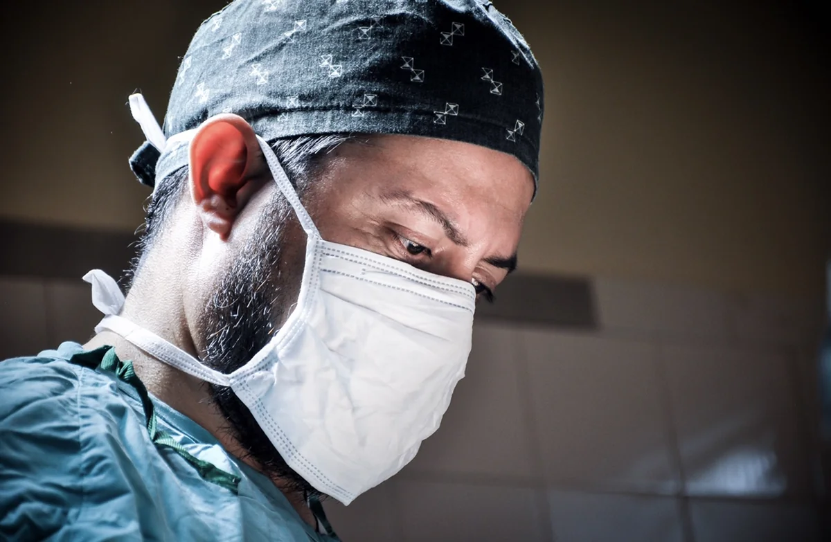 Dr. Rodrigo Mina concentrado en su trabajo en quirófano