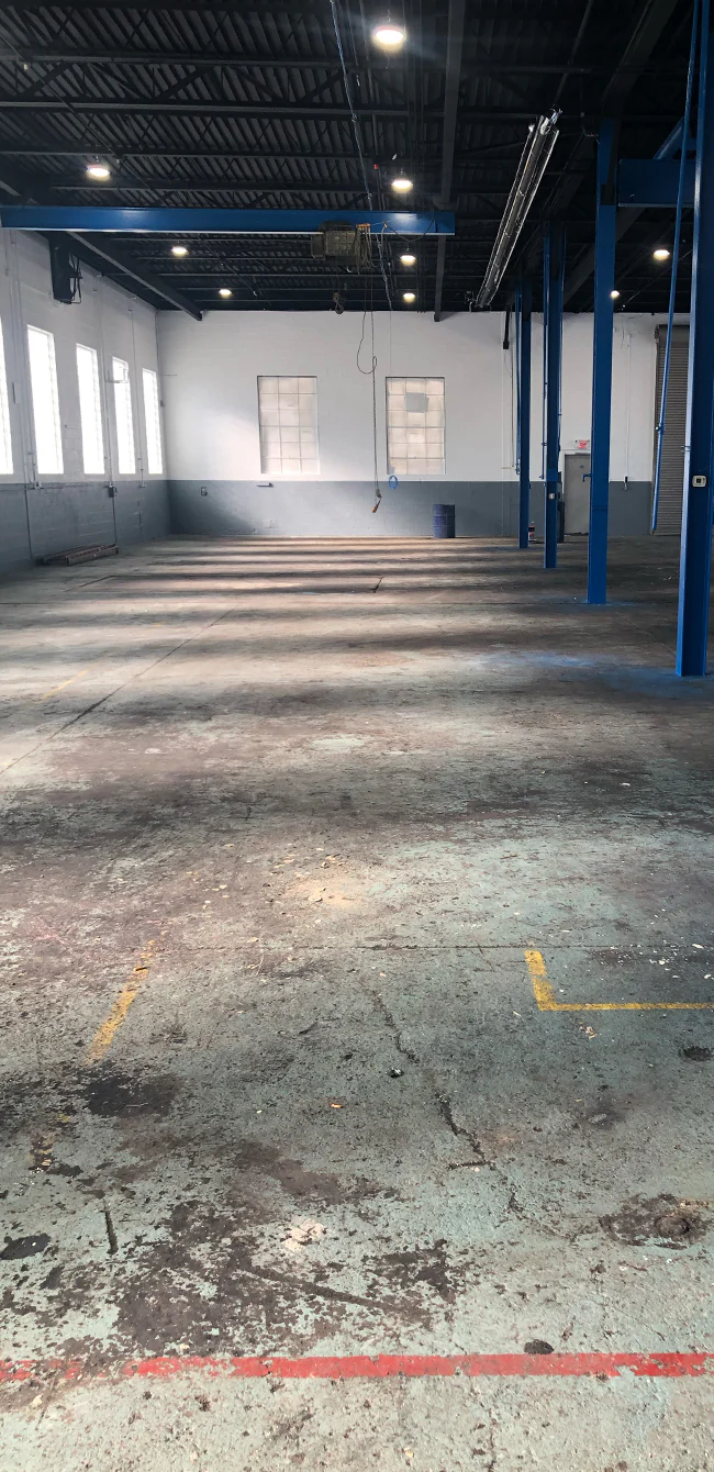 Bare, stained concrete floor before coating