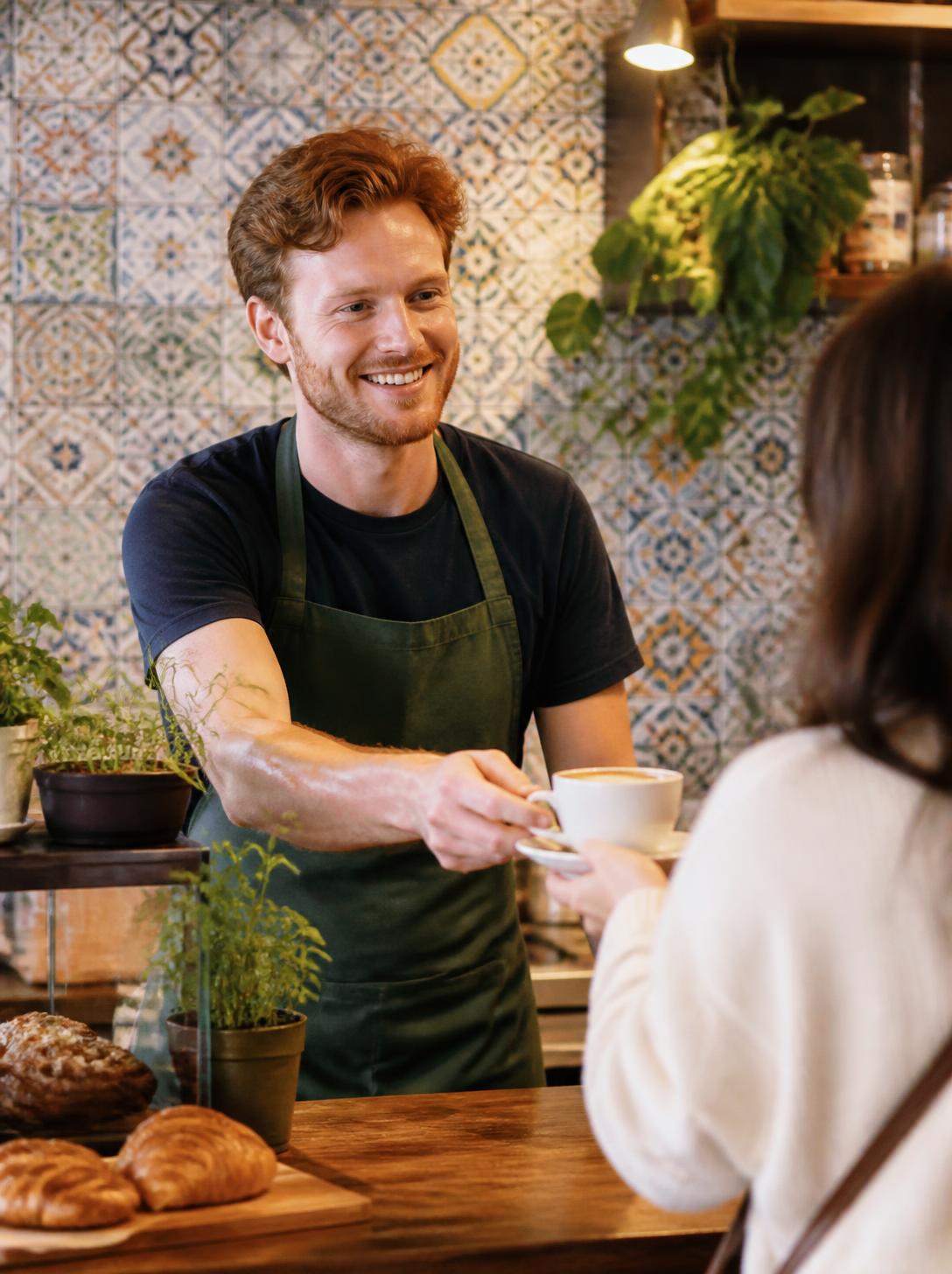 A coffee shop owner serving a customer