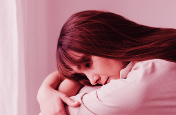 Woman hugging herself sadly