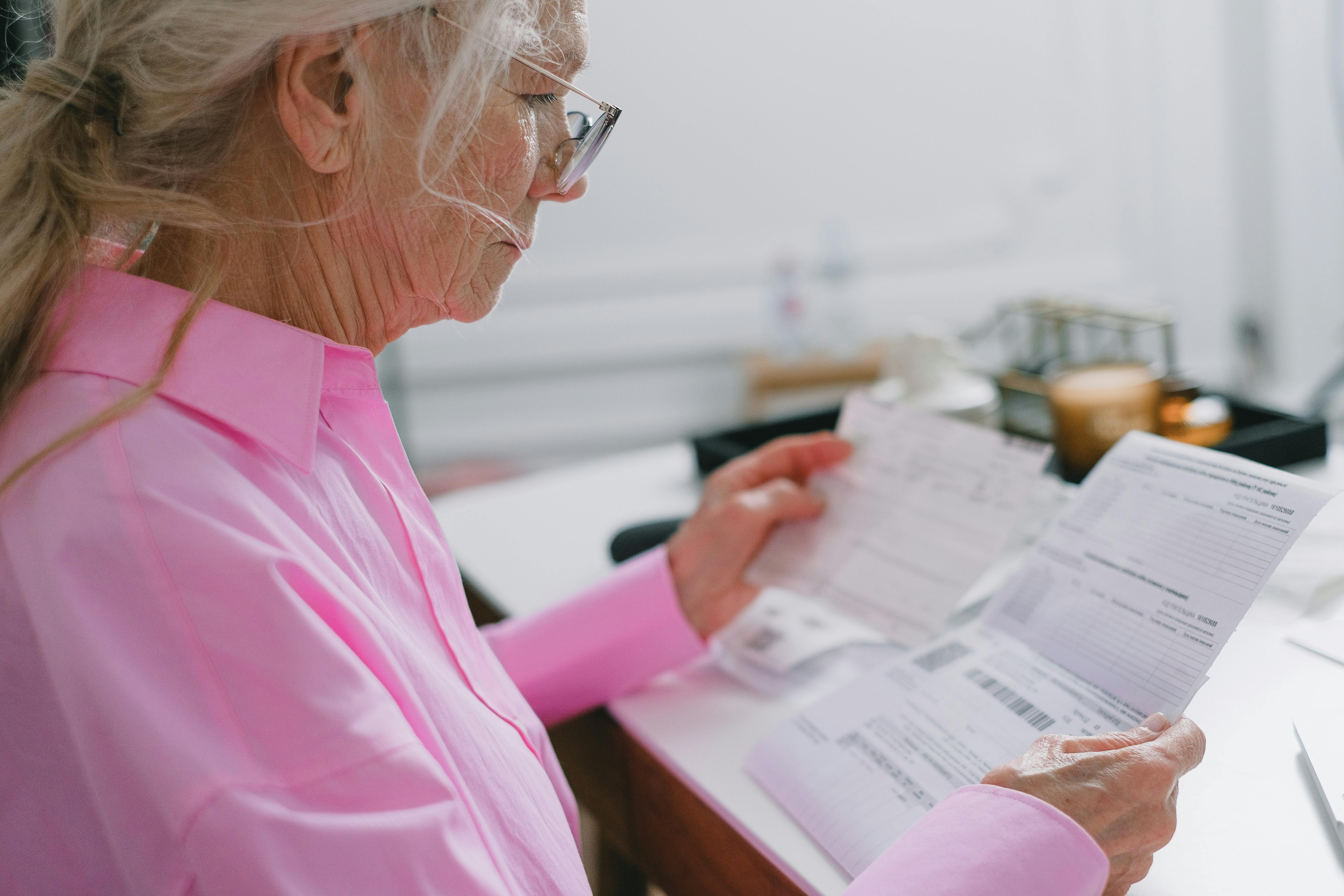 Senior homeowner reviewing tax notices and paperwork. Senior homeowner reviewing tax notices and paperwork.