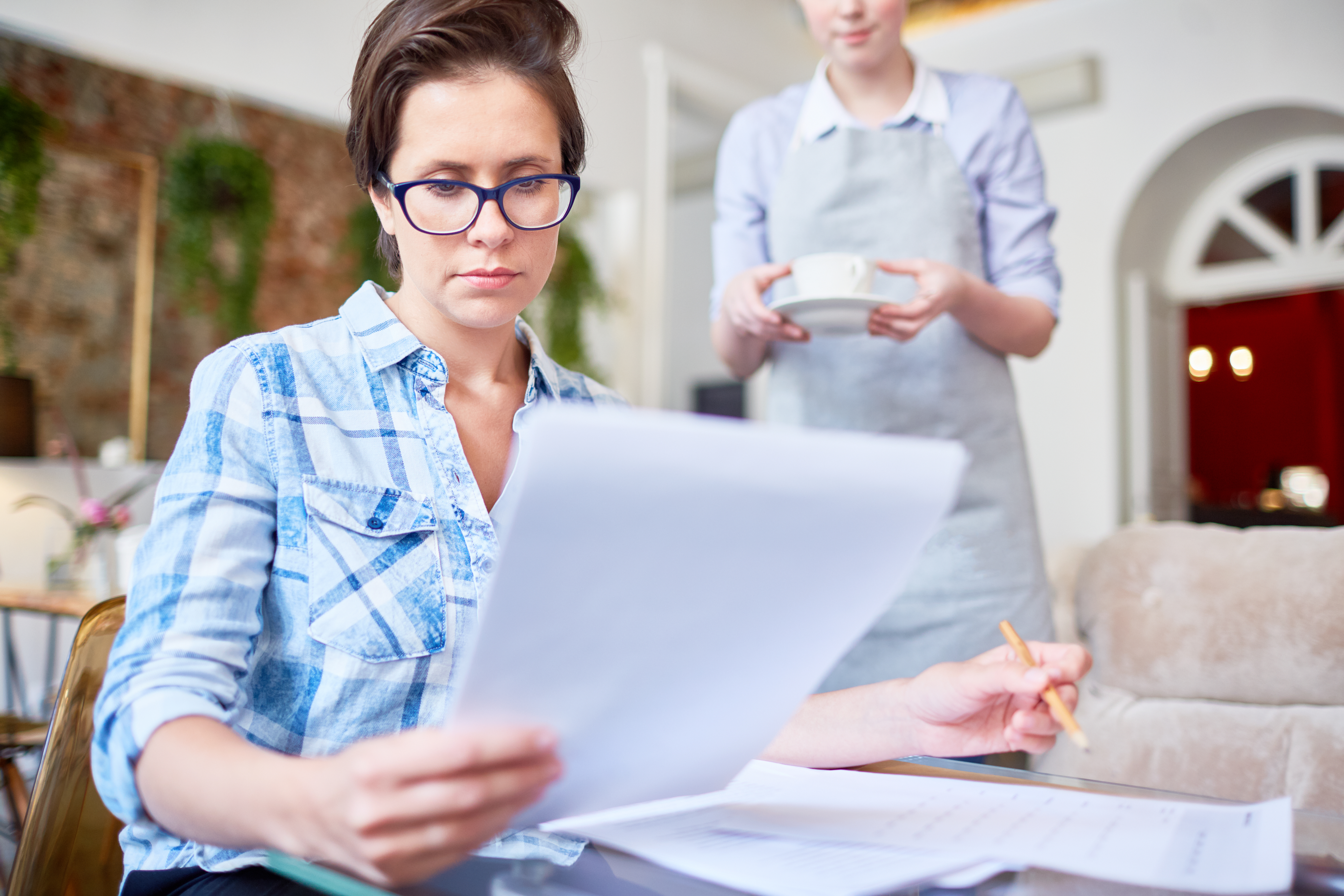 Alt Text: Homeowner reviewing closing paperwork while learning about deed fraud risks.
