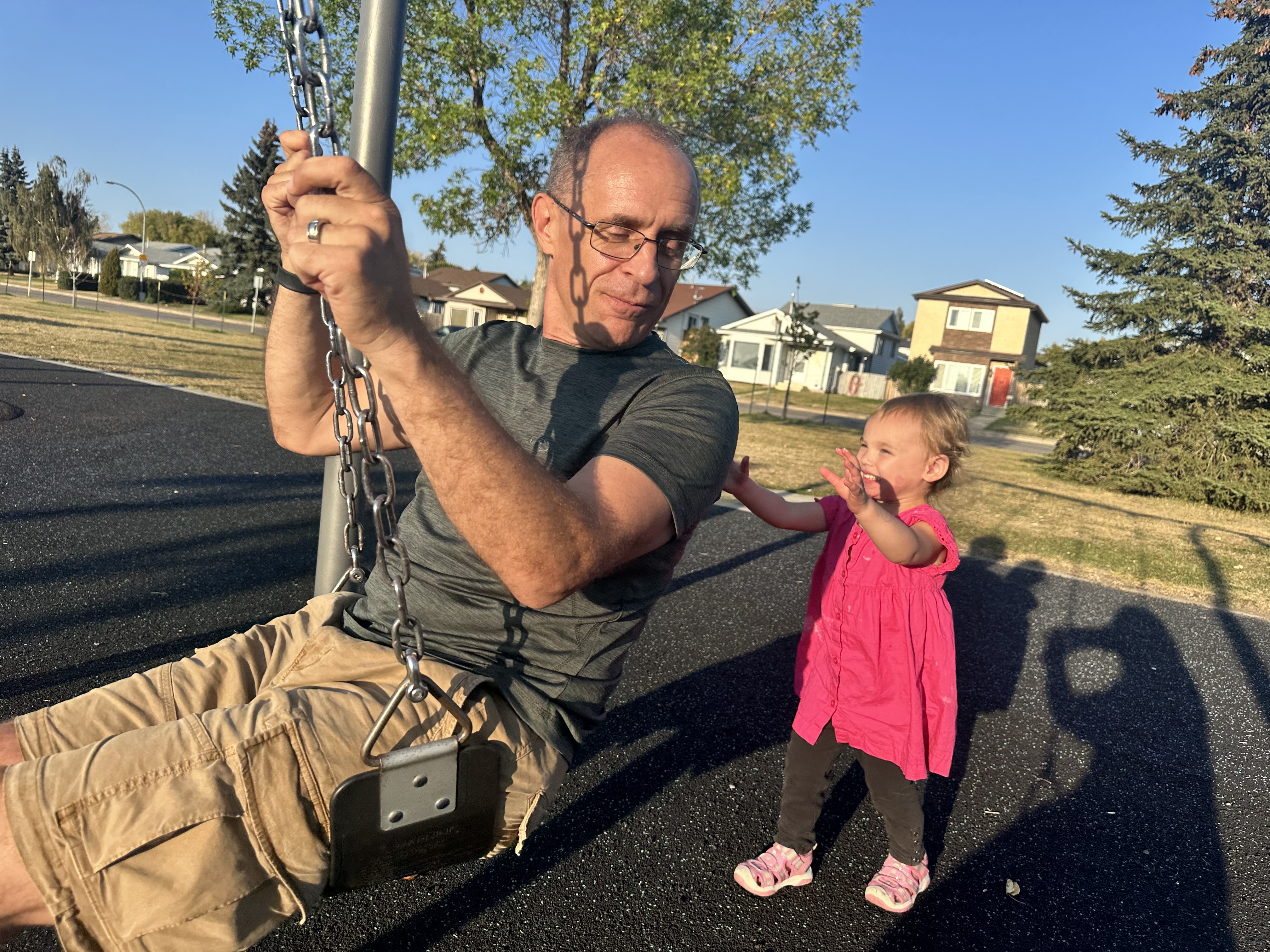 Harlie pushing grandpa Thomas on the swing