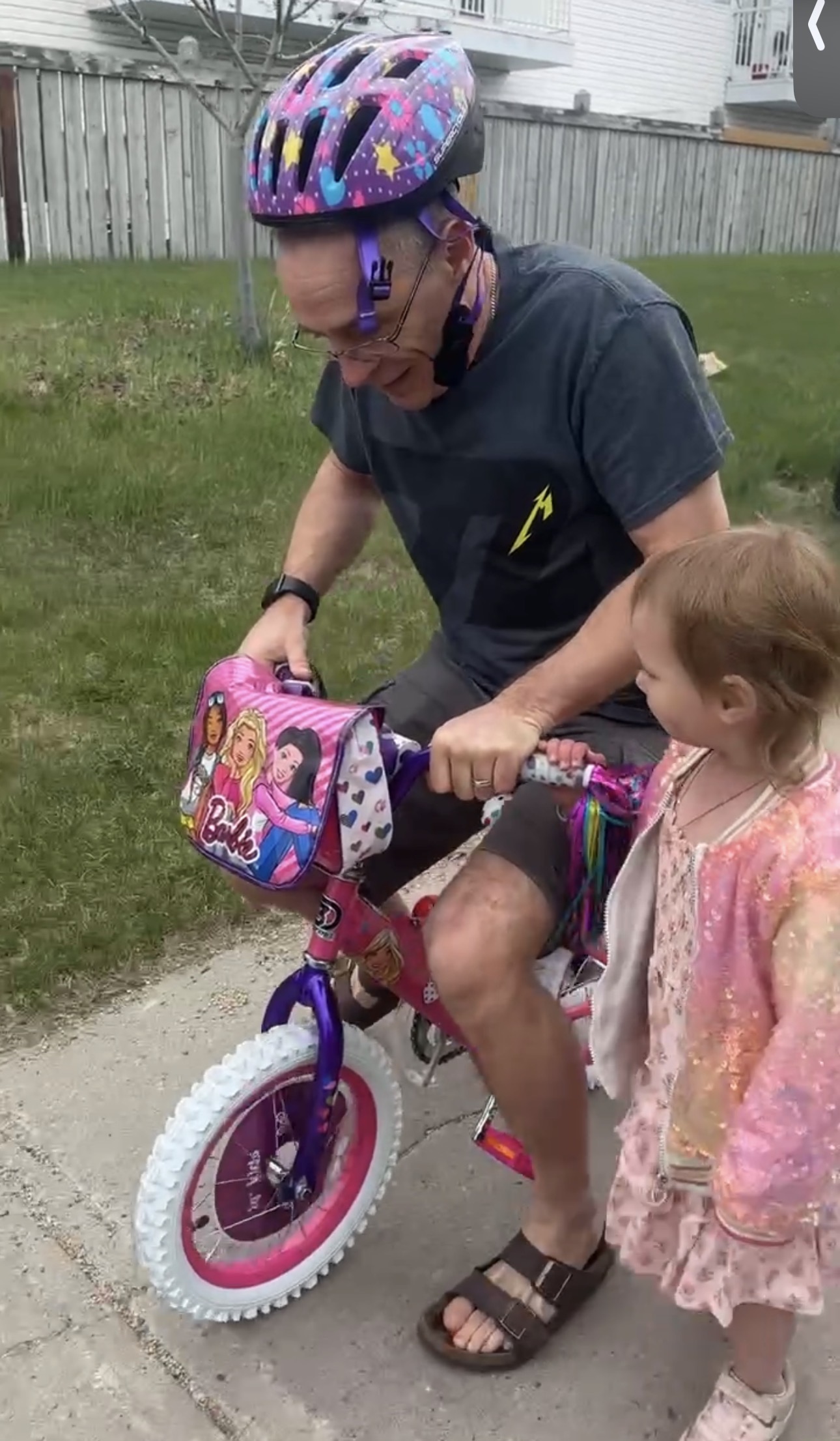 Harlie helping grandpa Thomas on the Barbie bike