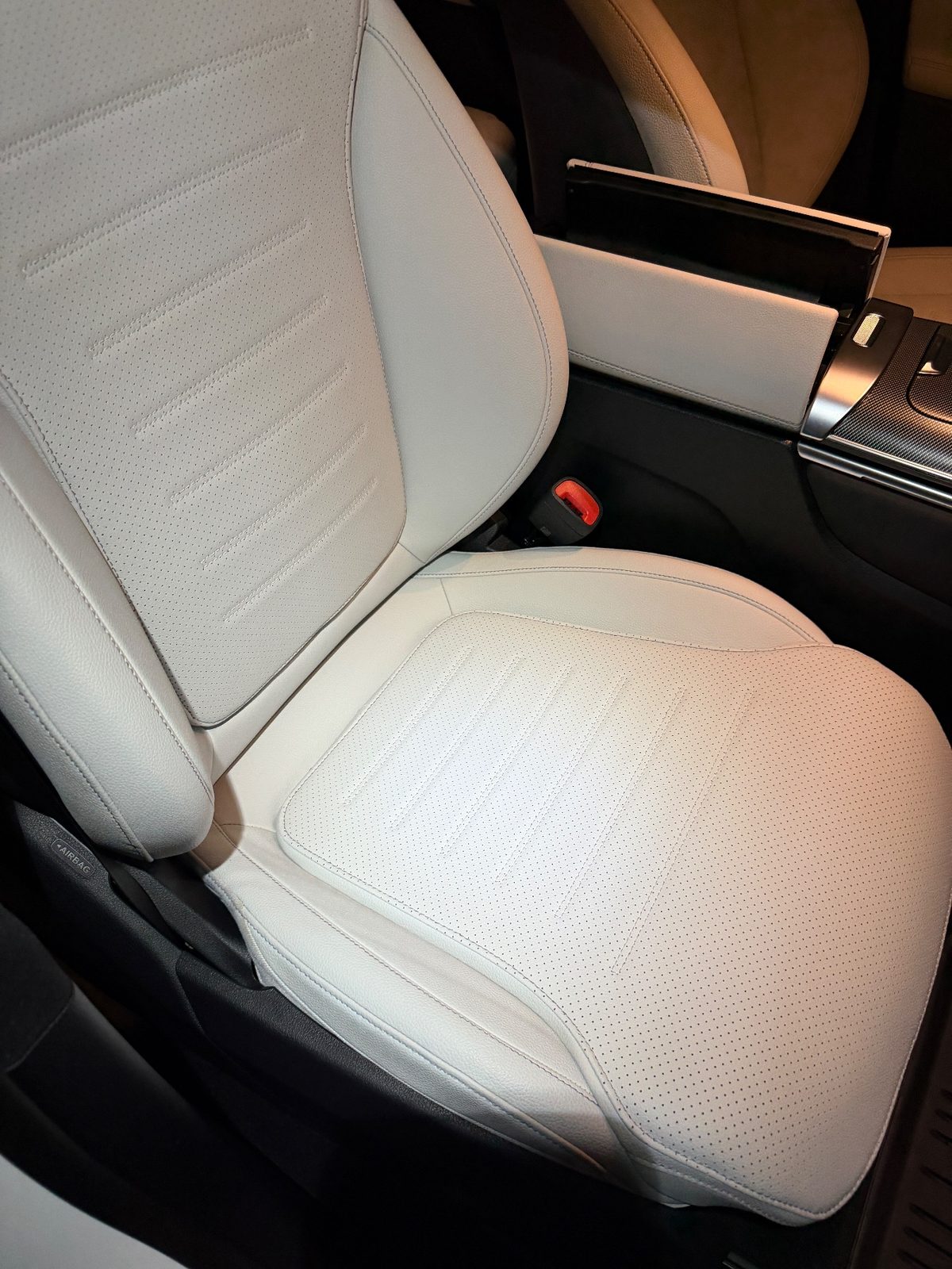 Driver seat of a white Mercedes GLC after detailing, clean bright cream leather