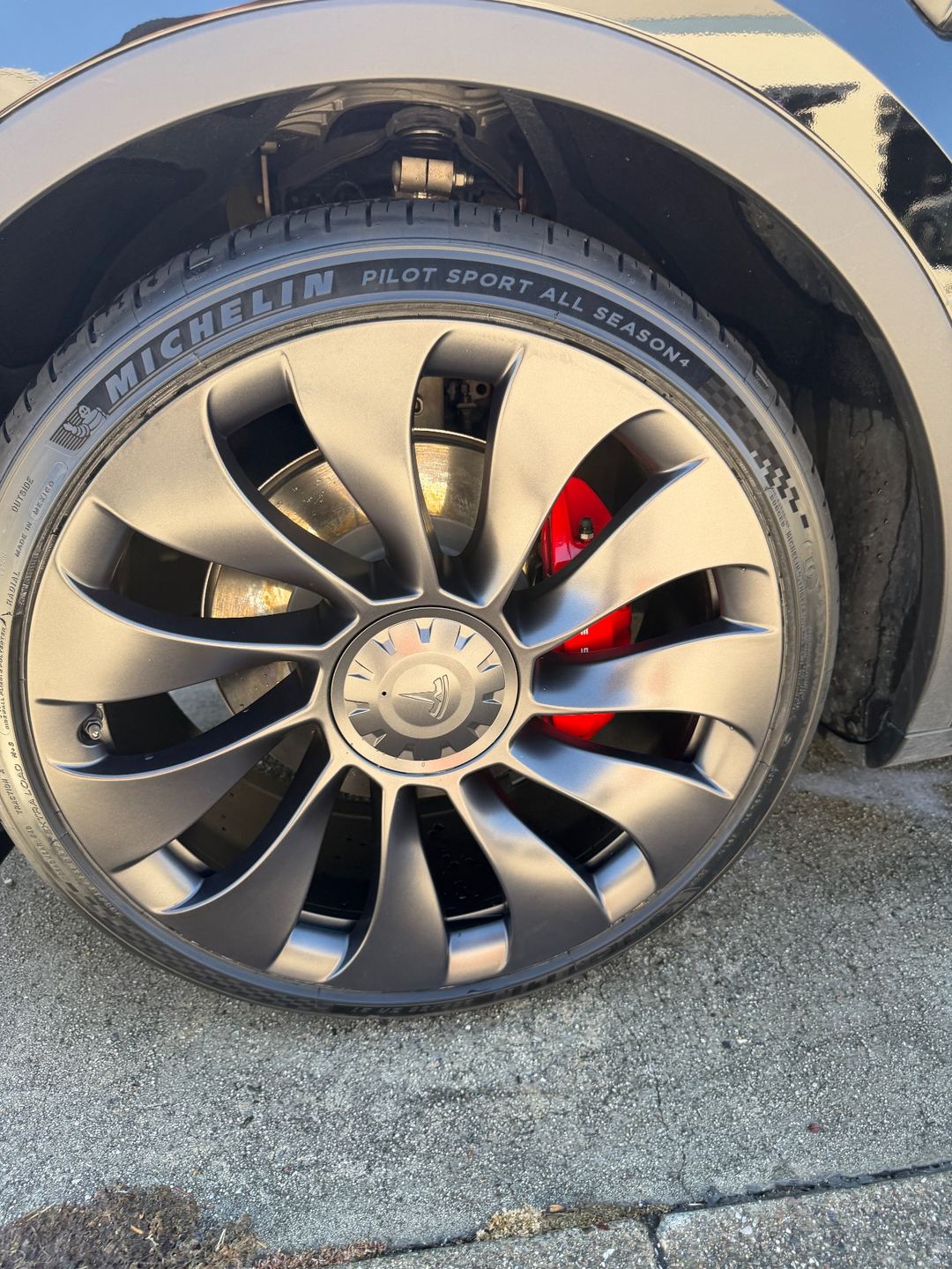 Clean 21-inch Uberturbine wheel with red brake caliper on a Tesla Model Y Performance