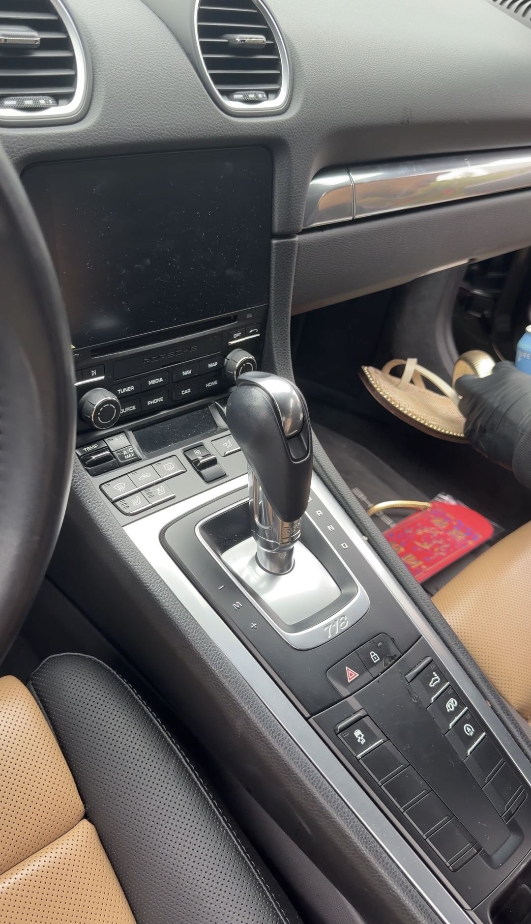 Dusty centre console and infotainment screen of a Porsche 718 Cayman S before an interior detail.