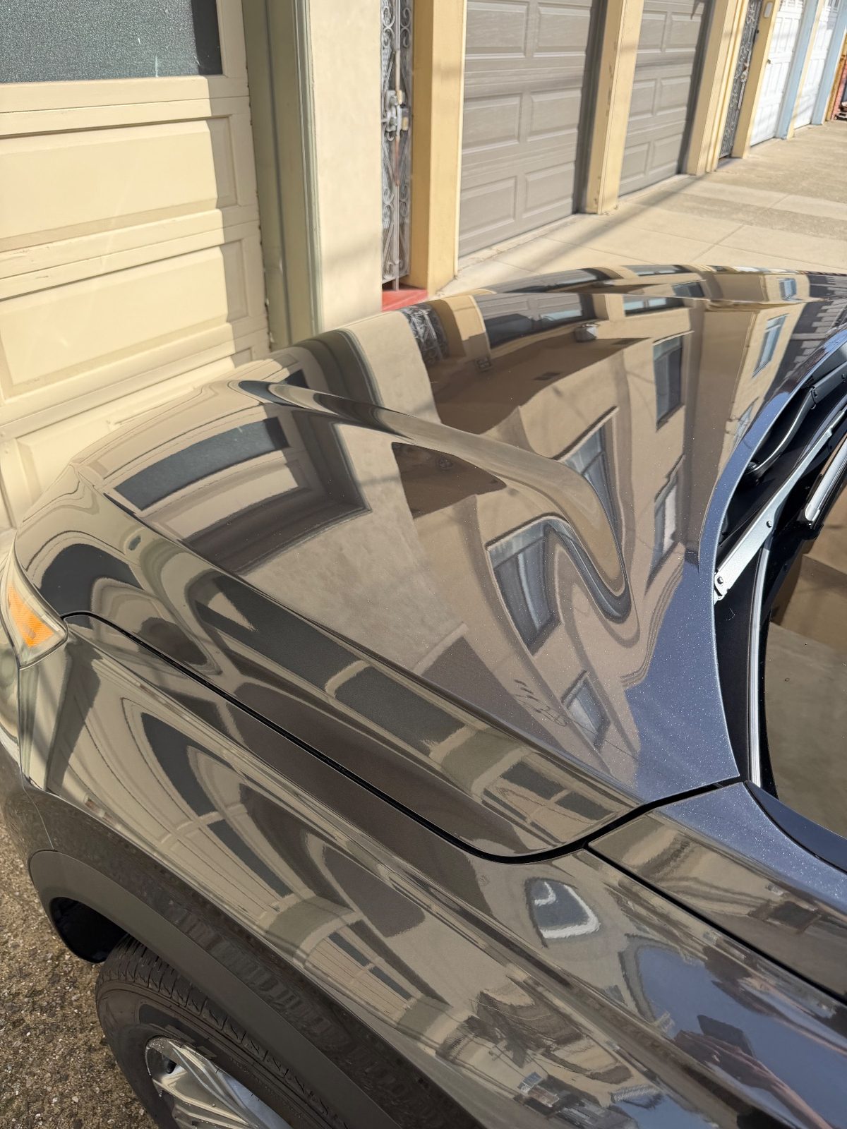 Glossy front fender and hood edge of a grey Hyundai Santa Fe after detailing