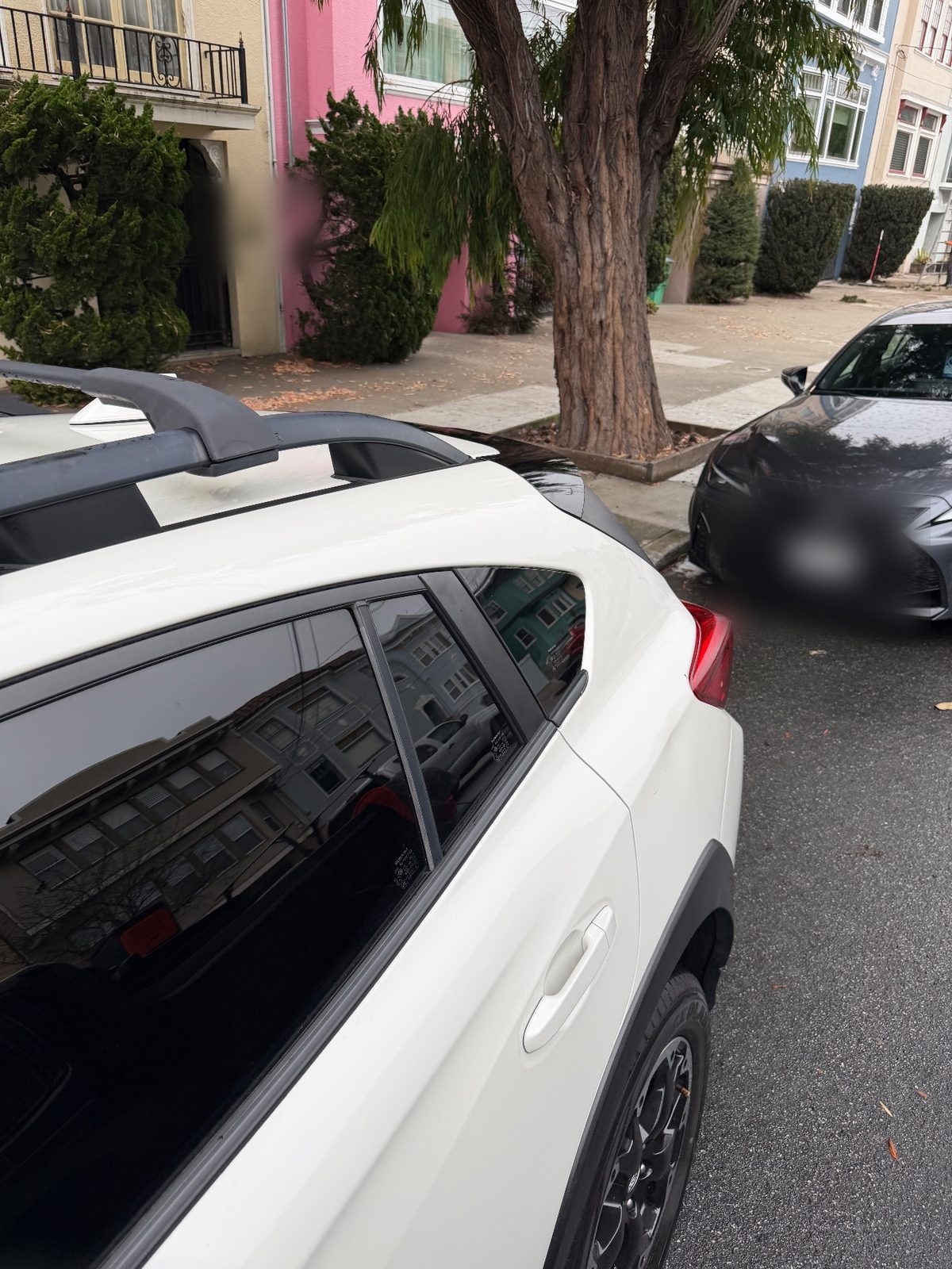 Clean glossy rear door and roof rails on a white Subaru Crosstrek after washing