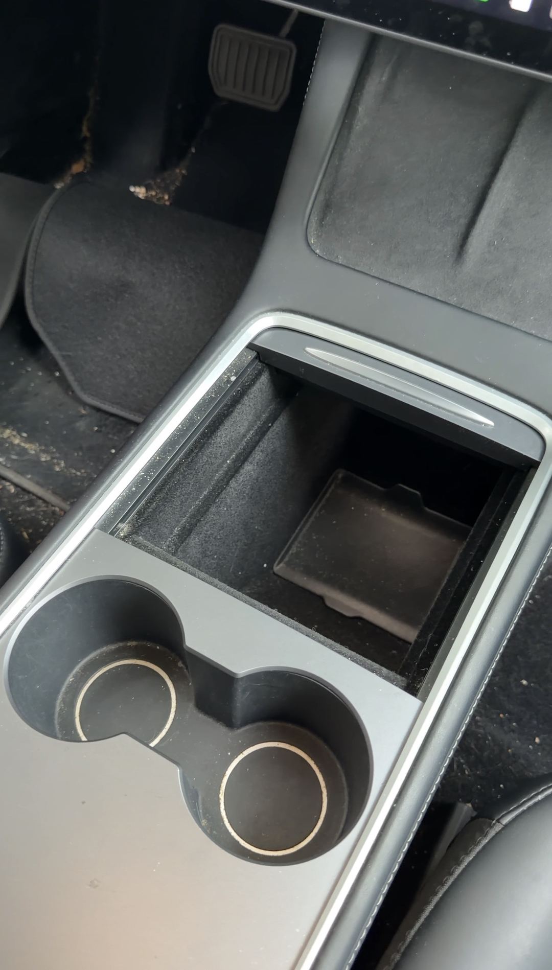 Tesla Model 3 center console before cleaning, crumbs in the cupholders and open storage bin