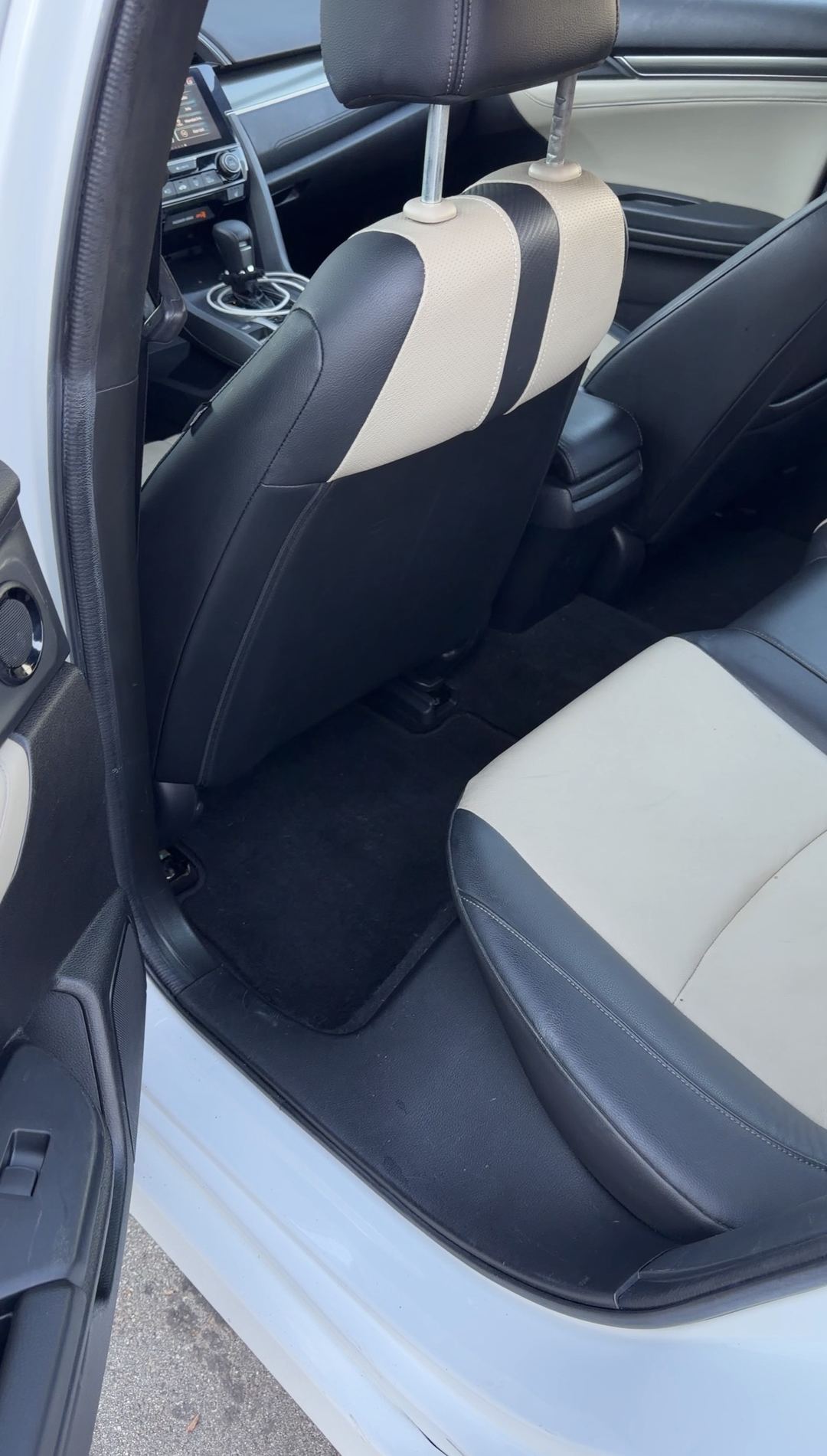 Cleaned rear passenger-side seat and floor of a Honda Civic after interior detailing