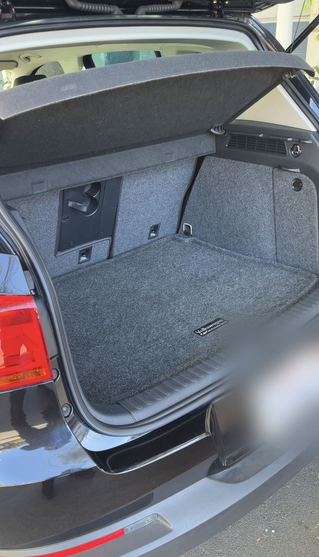 Boot of a black VW Tiguan after detailing, the Volkswagen cargo mat vacuumed clean.