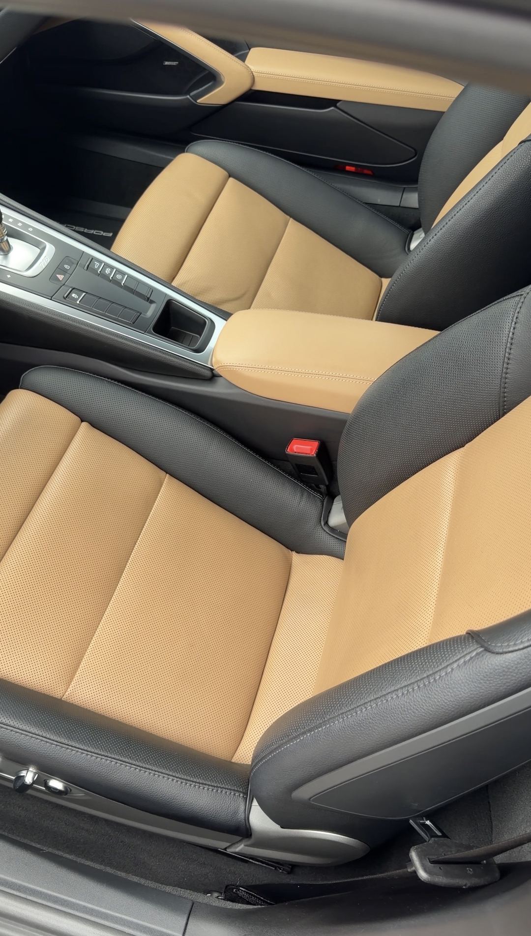 Clean saddle-brown leather front seats of a Porsche 718 Cayman S after an interior detail.