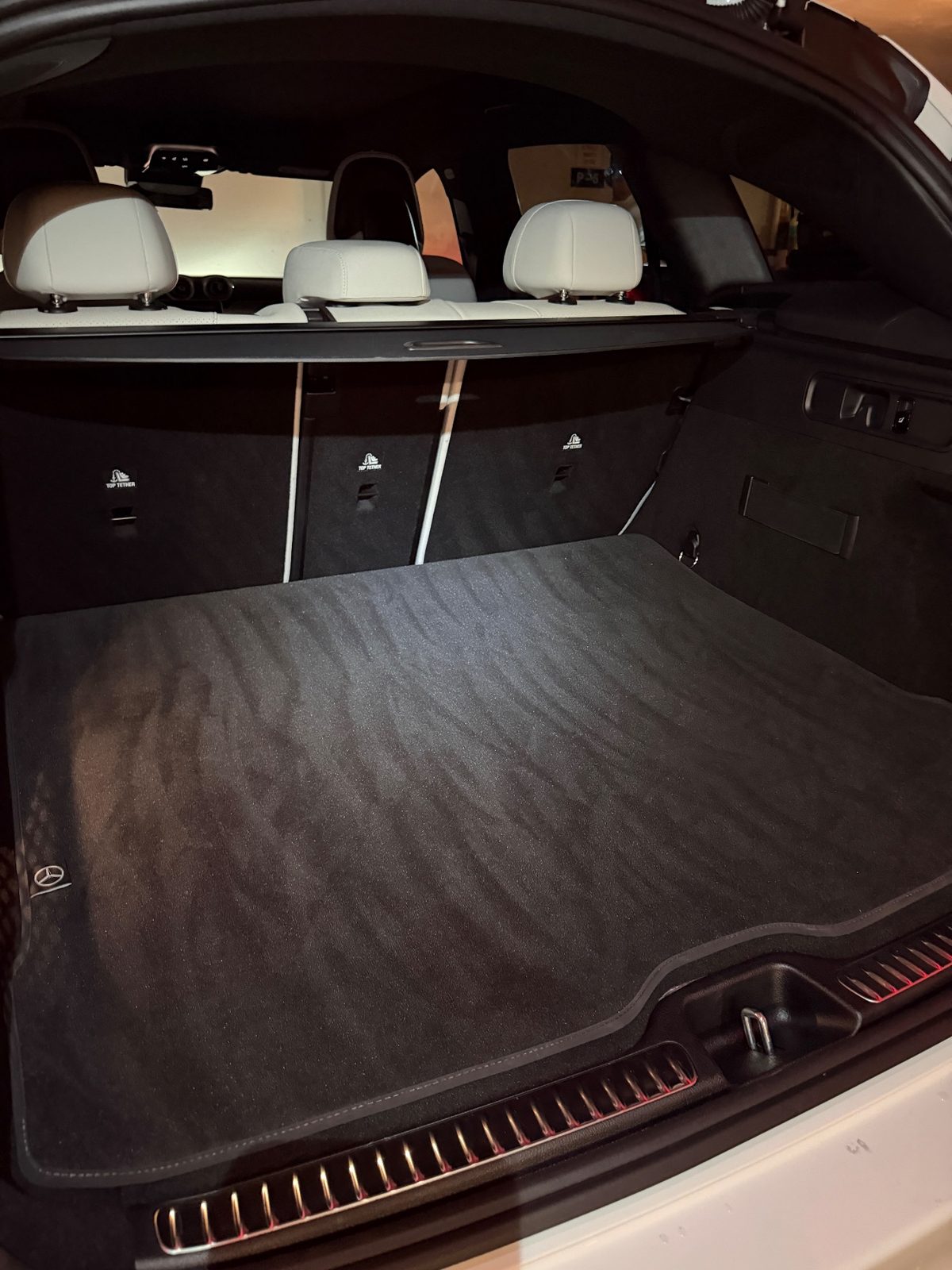 Cargo area of a white Mercedes GLC after vacuuming, clean black mat
