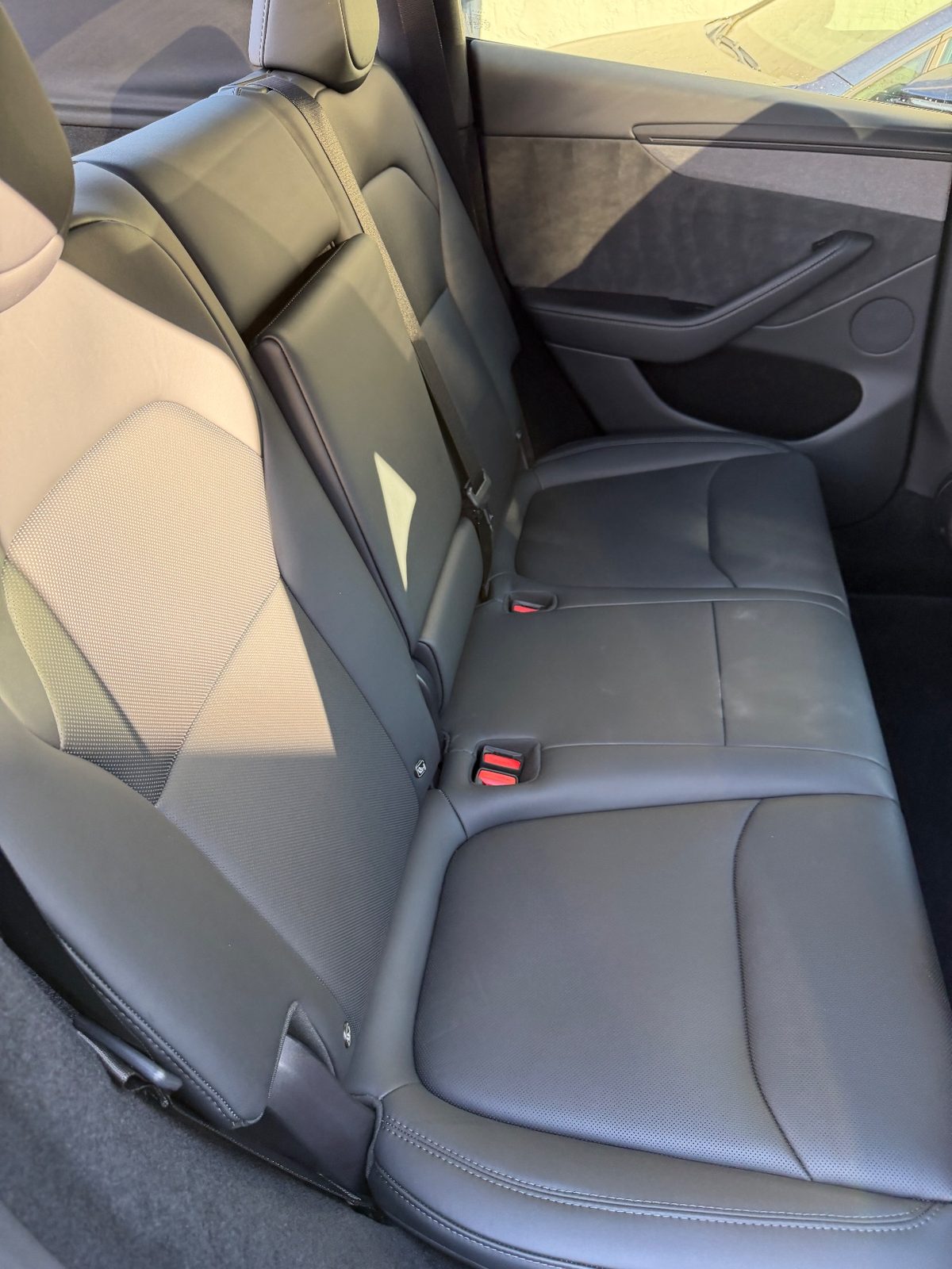 Clean rear leather seat of a white Tesla Model Y after detailing