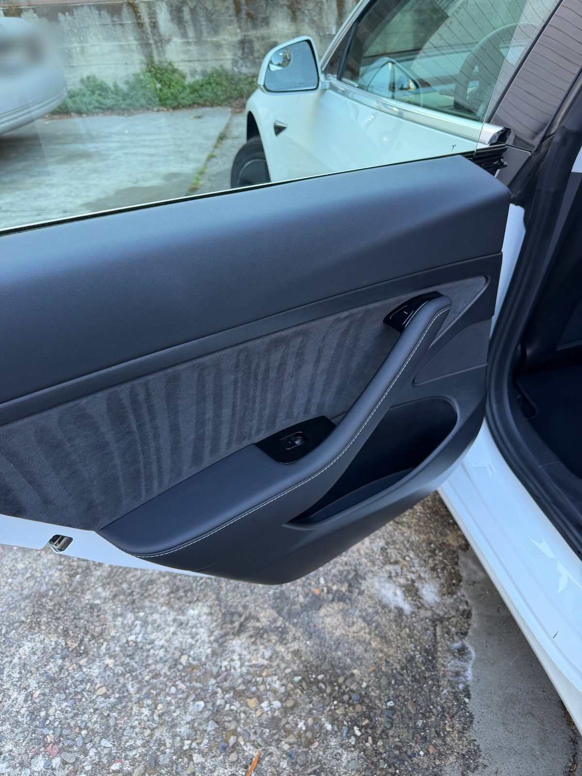 Clean rear door card of a white Tesla Model 3 after detailing