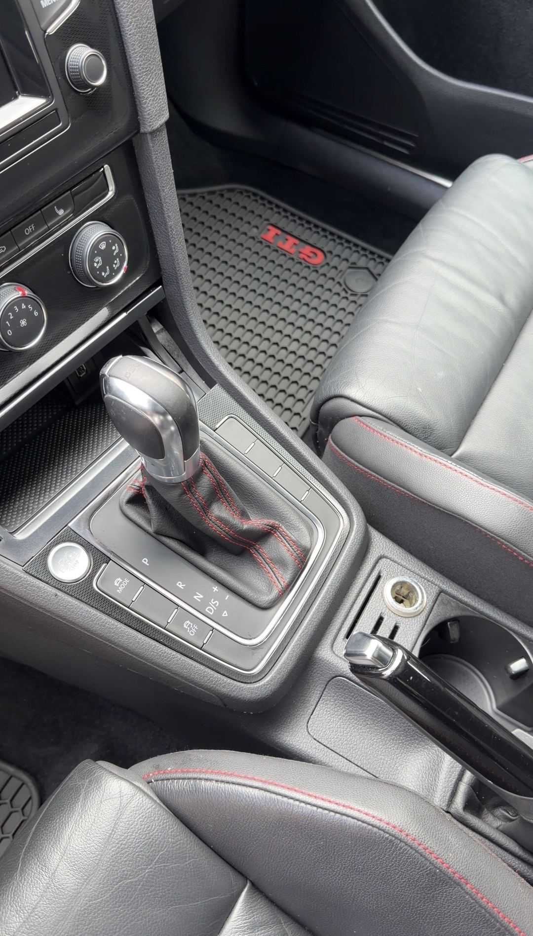 Shift lever and console of a VW GTI after cleaning, passenger GTI mat behind