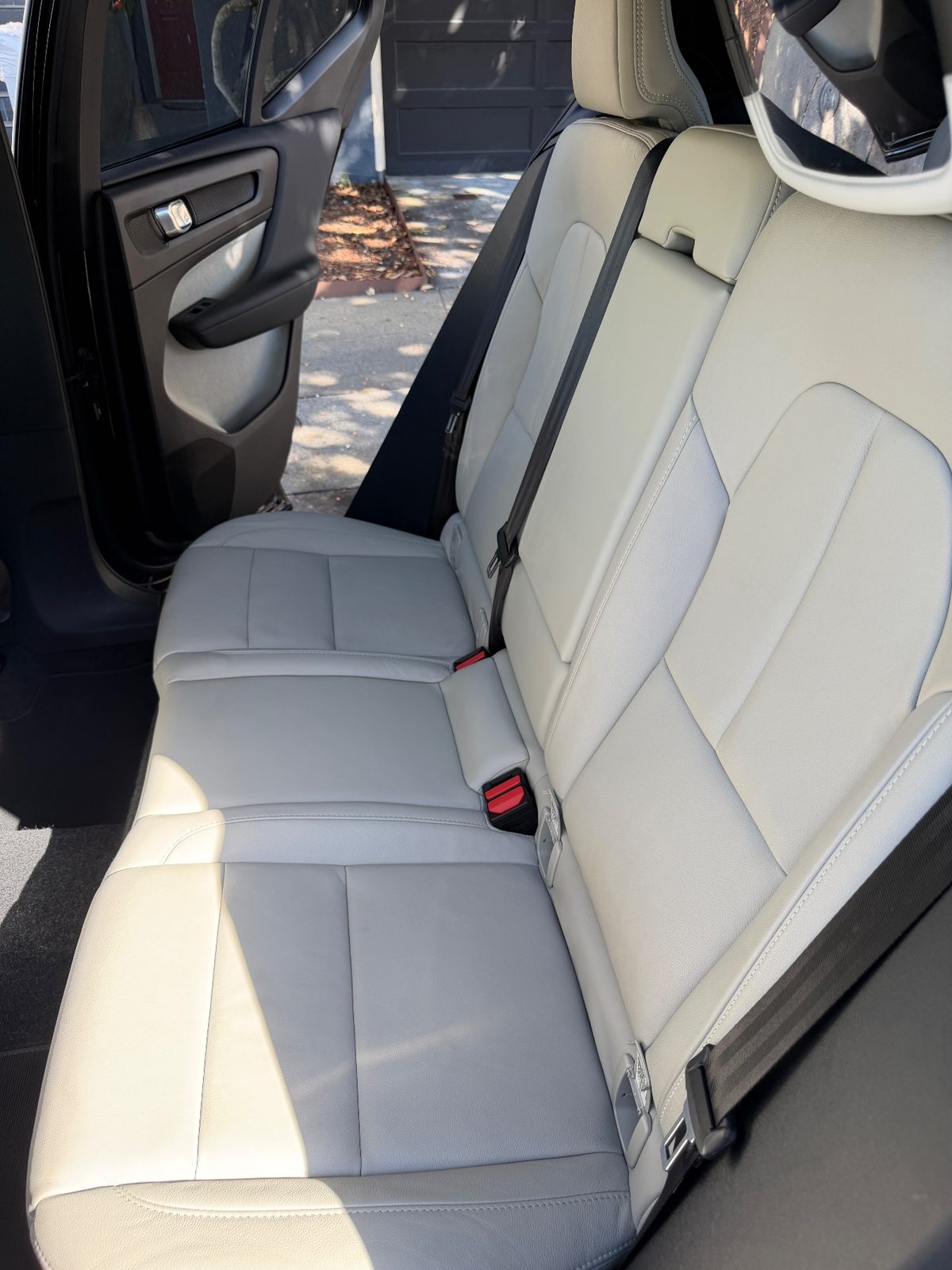 Rear bench seat of a Volvo XC40 after detailing, with clean even light grey leather