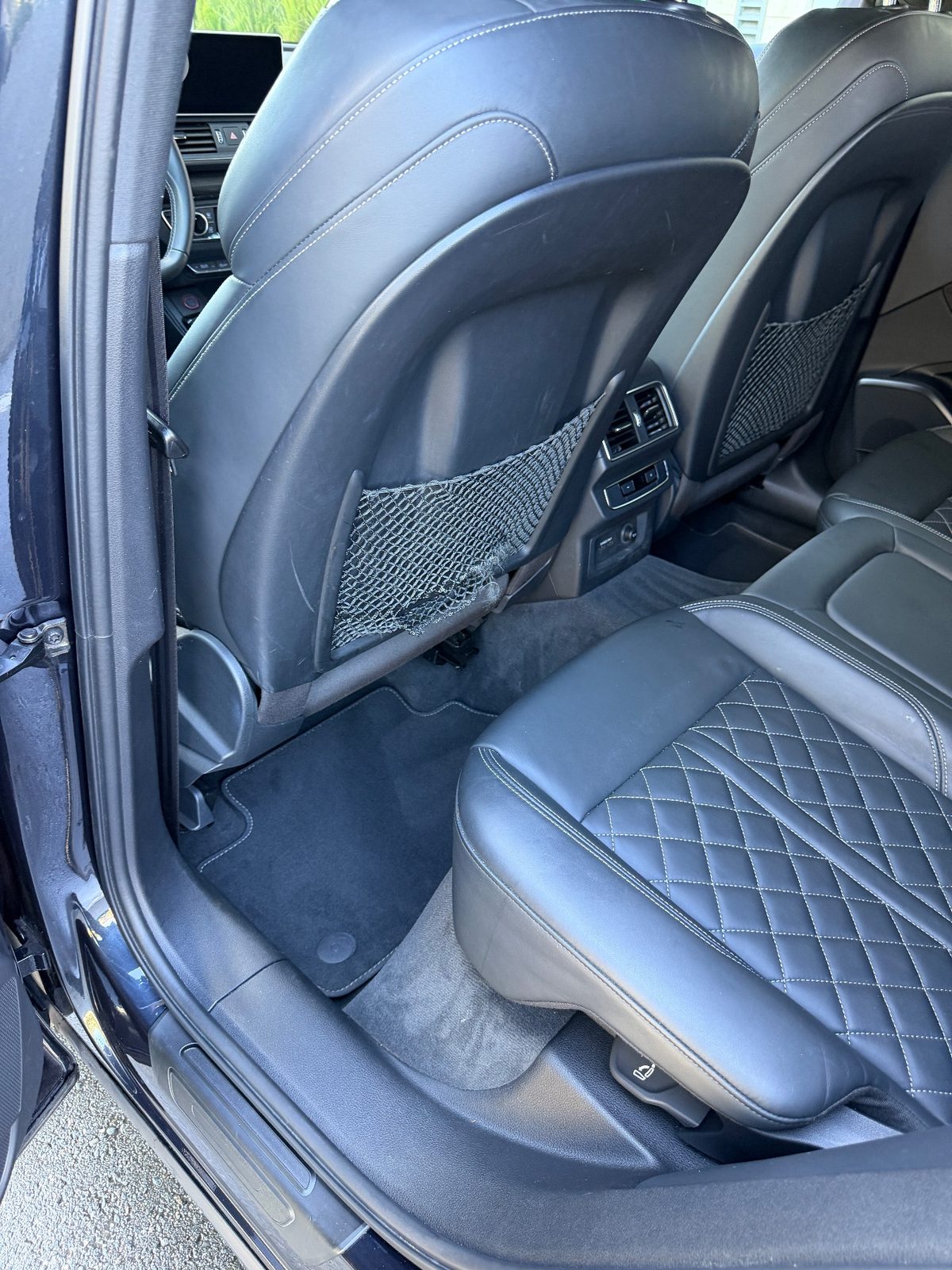 Rear footwell of an Audi SQ5 after detailing, with a clean vacuumed mat
