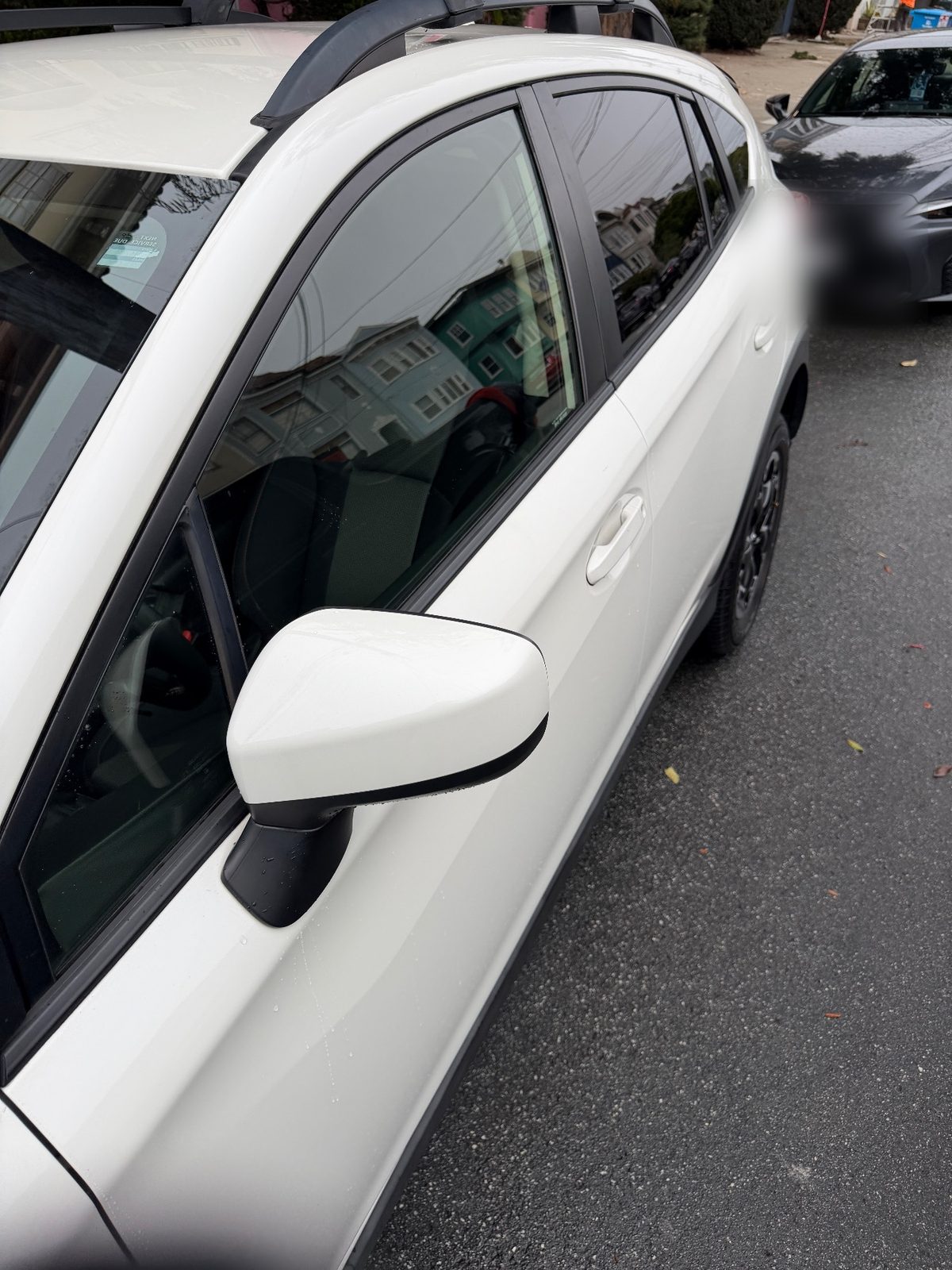 Clean glossy driver side of a white Subaru Crosstrek after washing