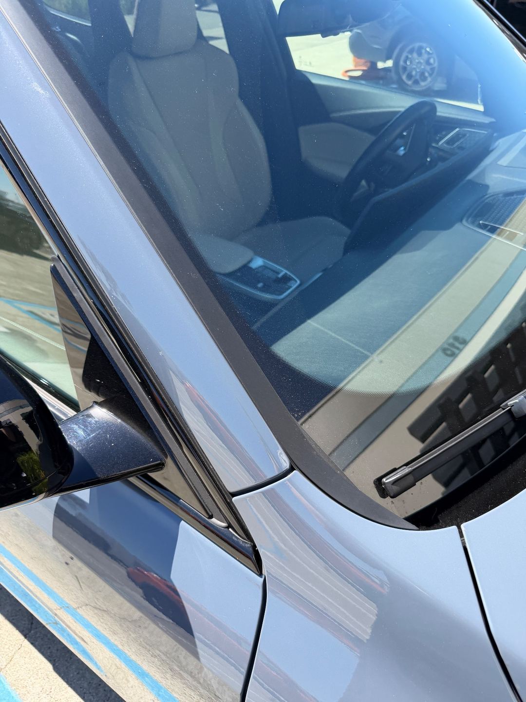 Windshield and mirror of a grey BMW X1 before washing