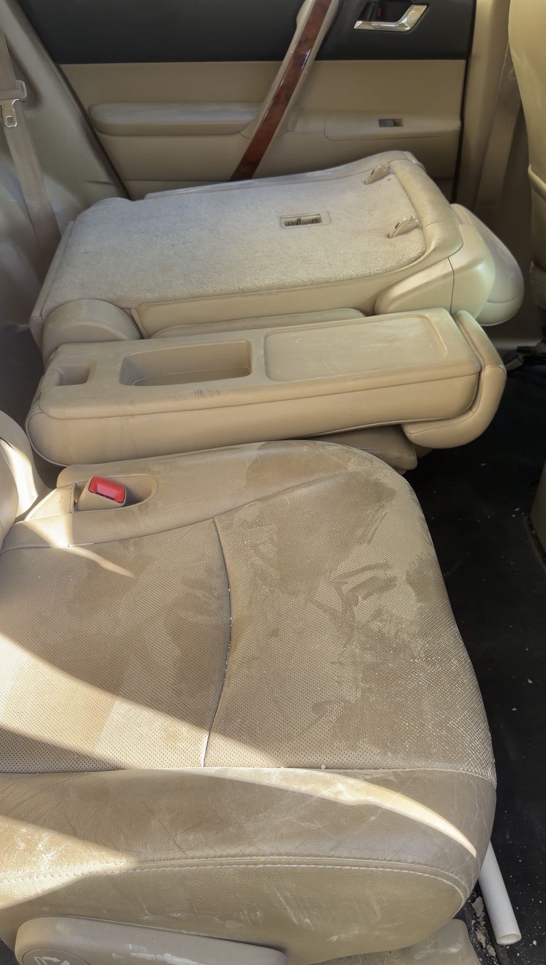 Dusty second-row seats of a Toyota Highlander with the centre seat folded