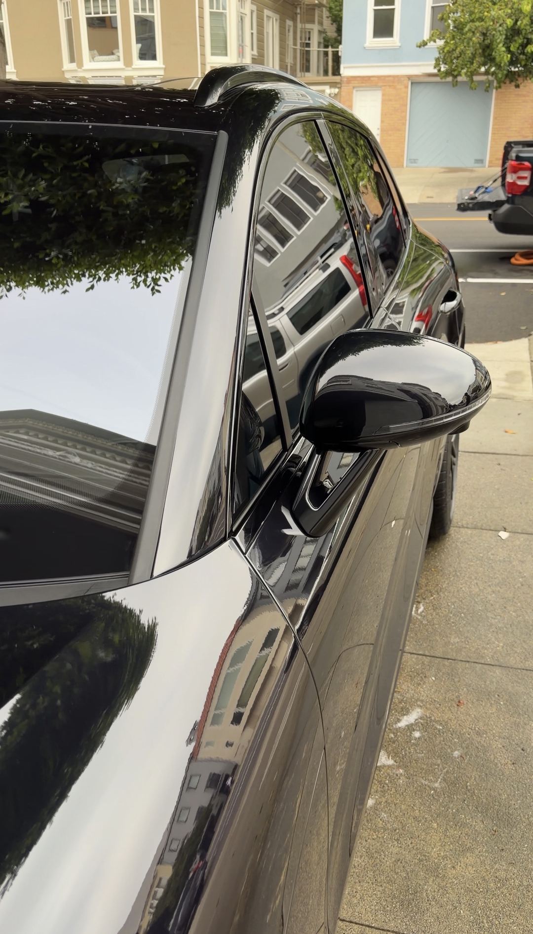 Spotless windshield and gloss-black mirror of a black Porsche Macan GTS after a San Francisco mobile detail.