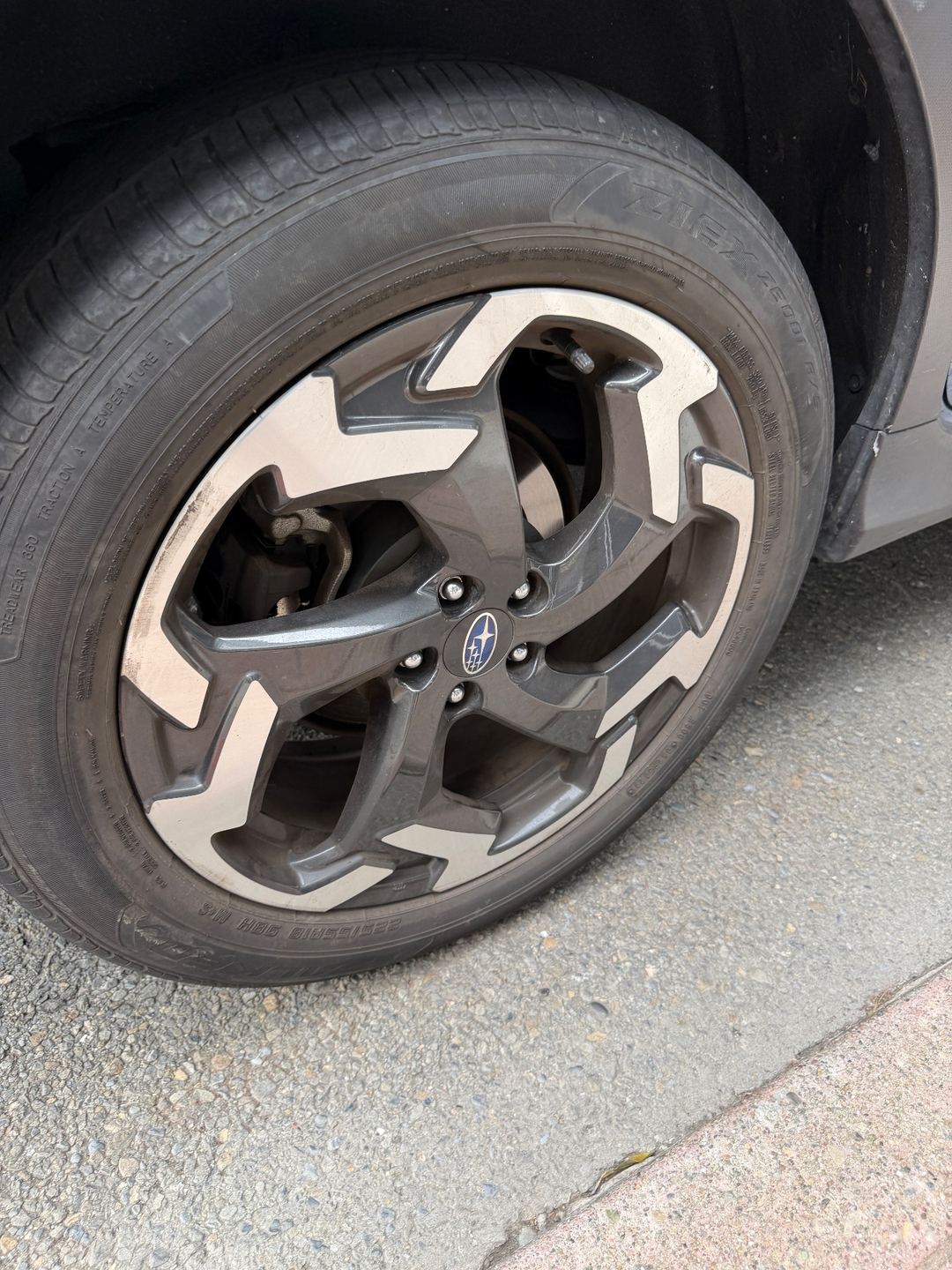 Alloy wheel and tyre of a Subaru Crosstrek before cleaning, with brake dust dulling the spokes
