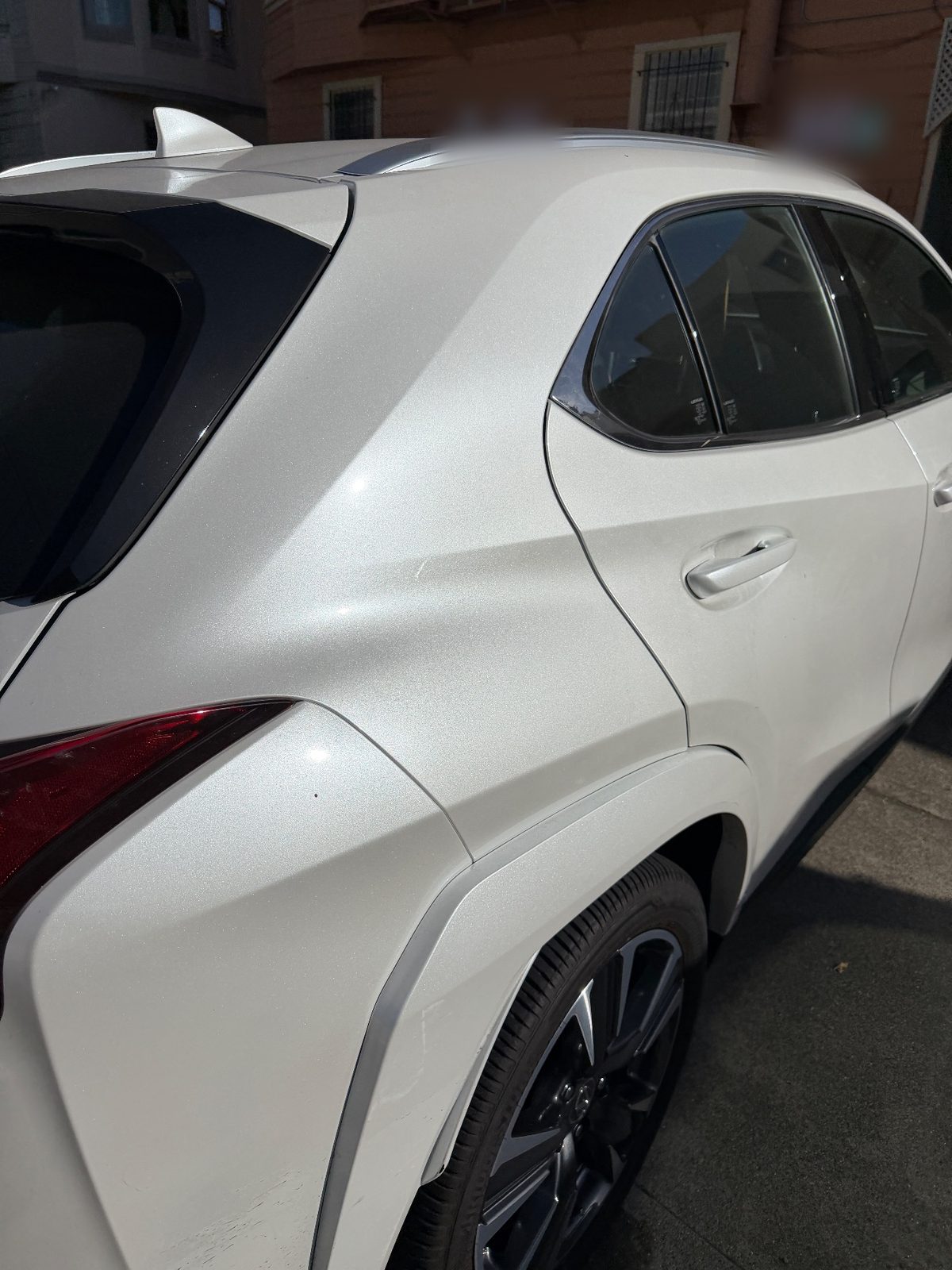 Rear quarter of a white Lexus UX before detailing with a dusty panel